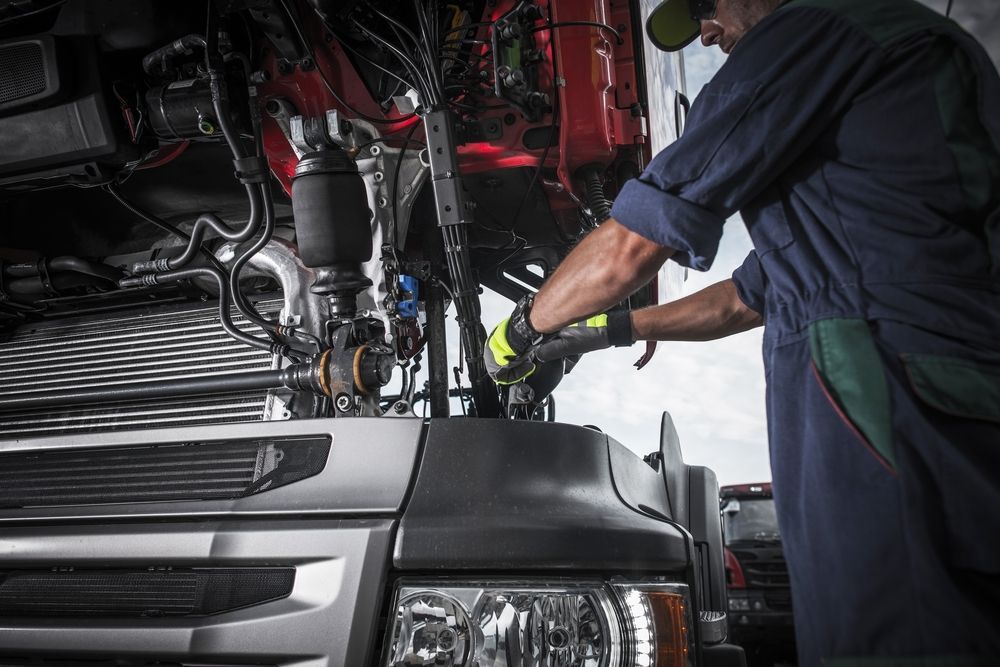 A Man is Working on the Engine of a Truck — Trucks On The Run Pty Ltd in Wyreema, QLD