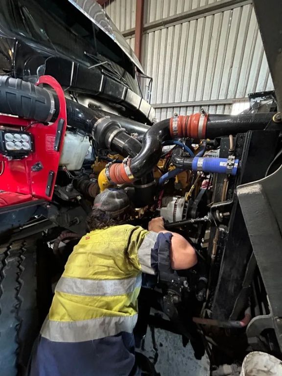 A Man is Working on a Truck Engine in a Garage — Trucks On The Run Pty Ltd in Wilsonton, QLD