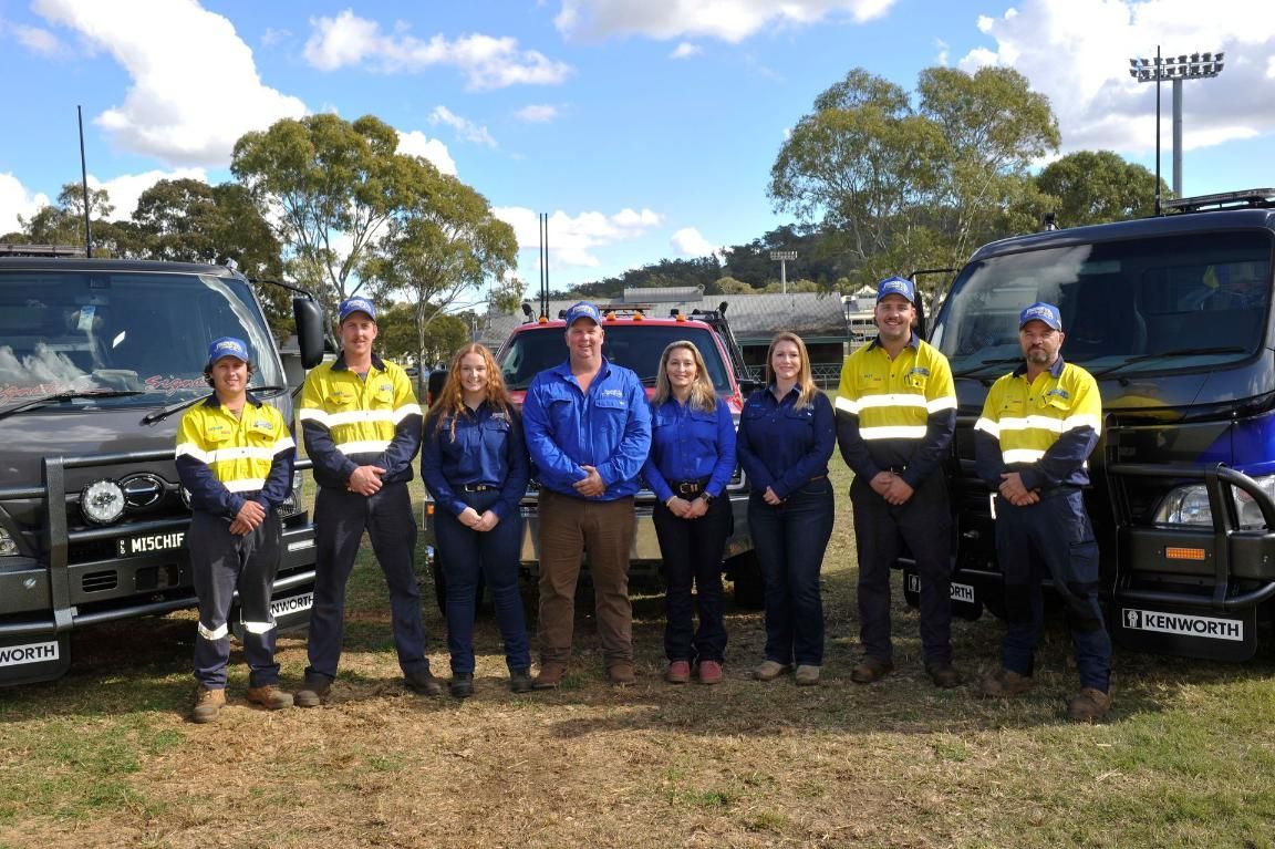A Group of People Are Standing in Front of Trucks — Trucks On The Run Pty Ltd in Wilsonton, QLD
