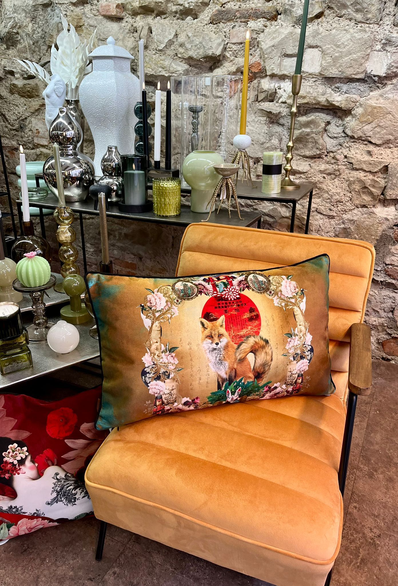 Une chaise jaune avec un coussin dessus est posée à côté d'une table avec des bougies dessus.