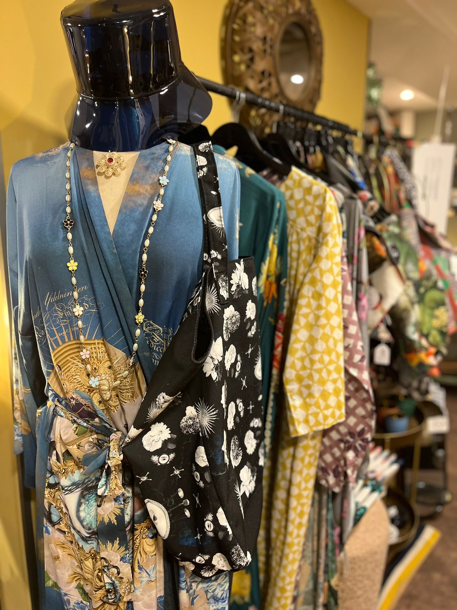 Un mannequin expose une variété de vêtements dans un magasin.