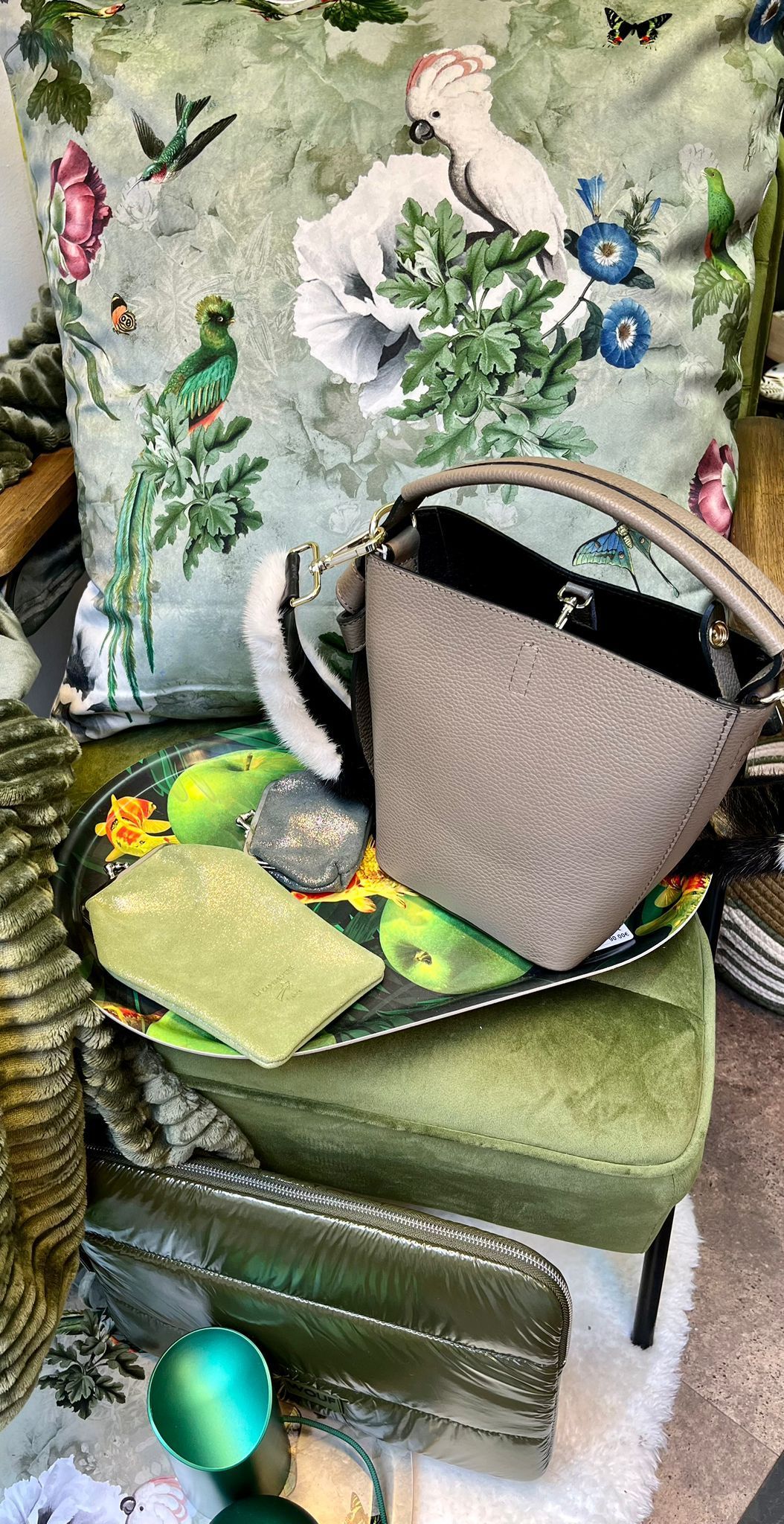 Un sac à main est posé sur une chaise verte à côté d'un oreiller.