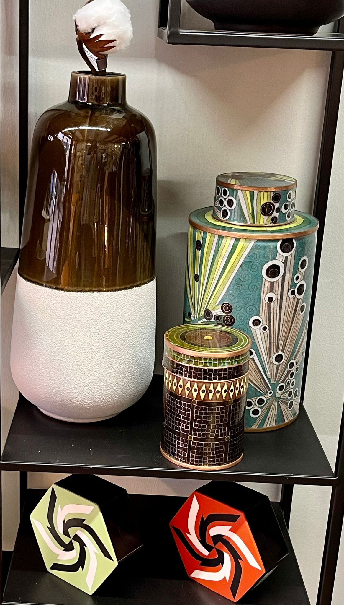 Trois vases sont posés sur une étagère les uns à côté des autres.