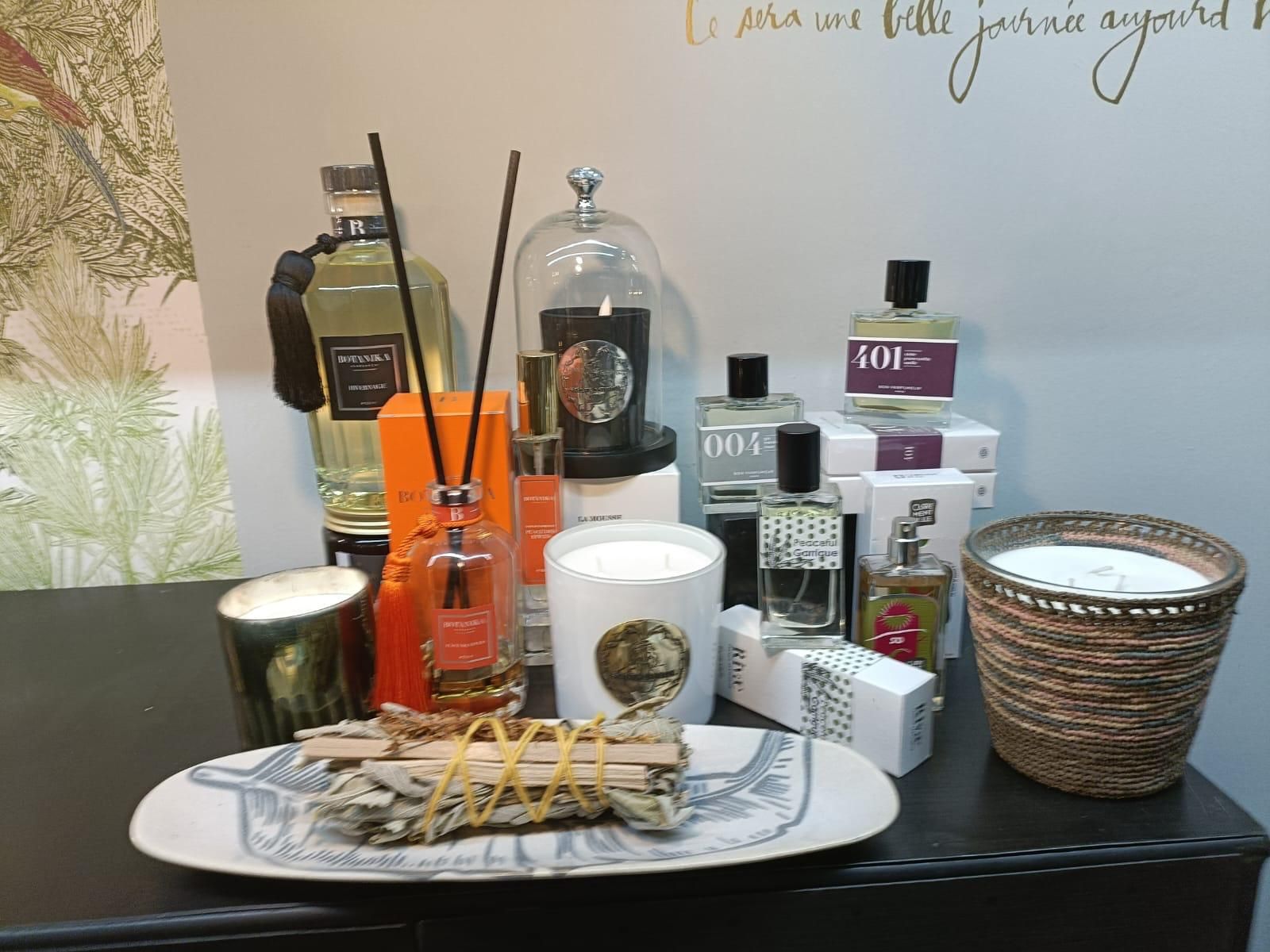 Une exposition de bougies et de flacons de parfum, dont un sur lequel est écrit gmc