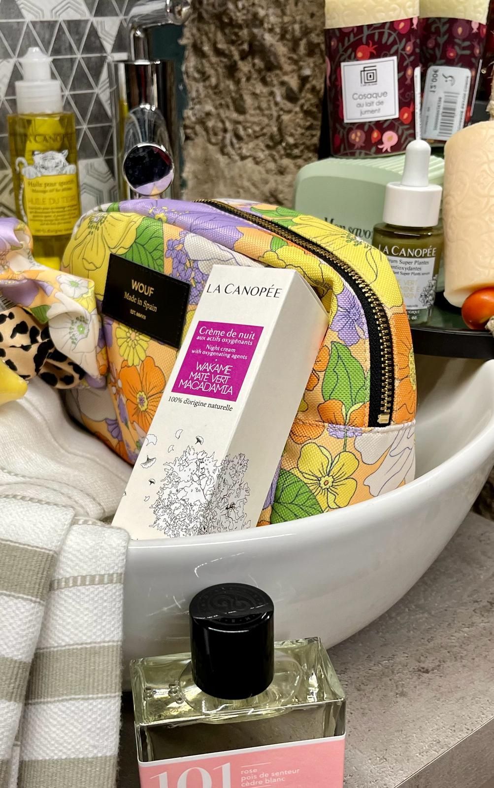 Un lavabo de salle de bain rempli de bouteilles de parfum et d'une trousse de maquillage.