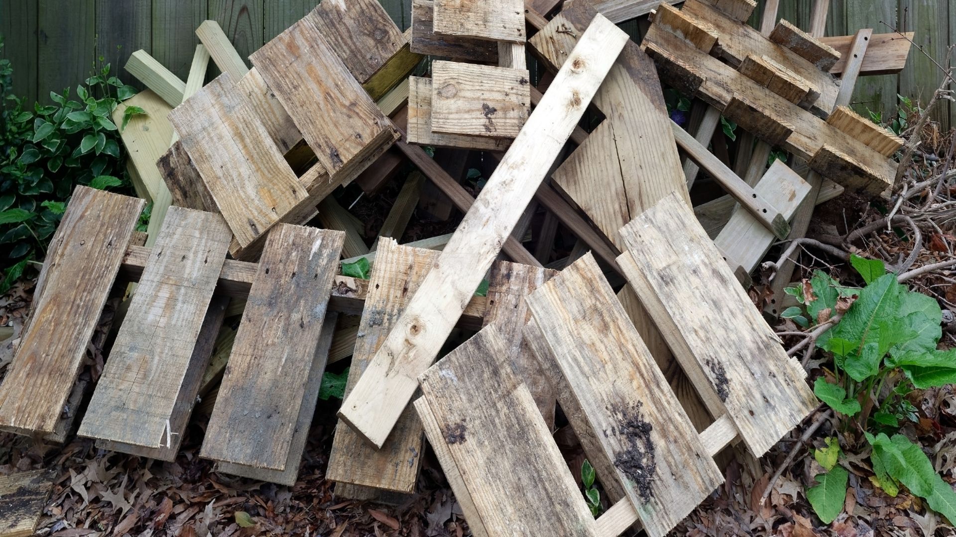 A pile of wooden pallets is sitting on the ground.