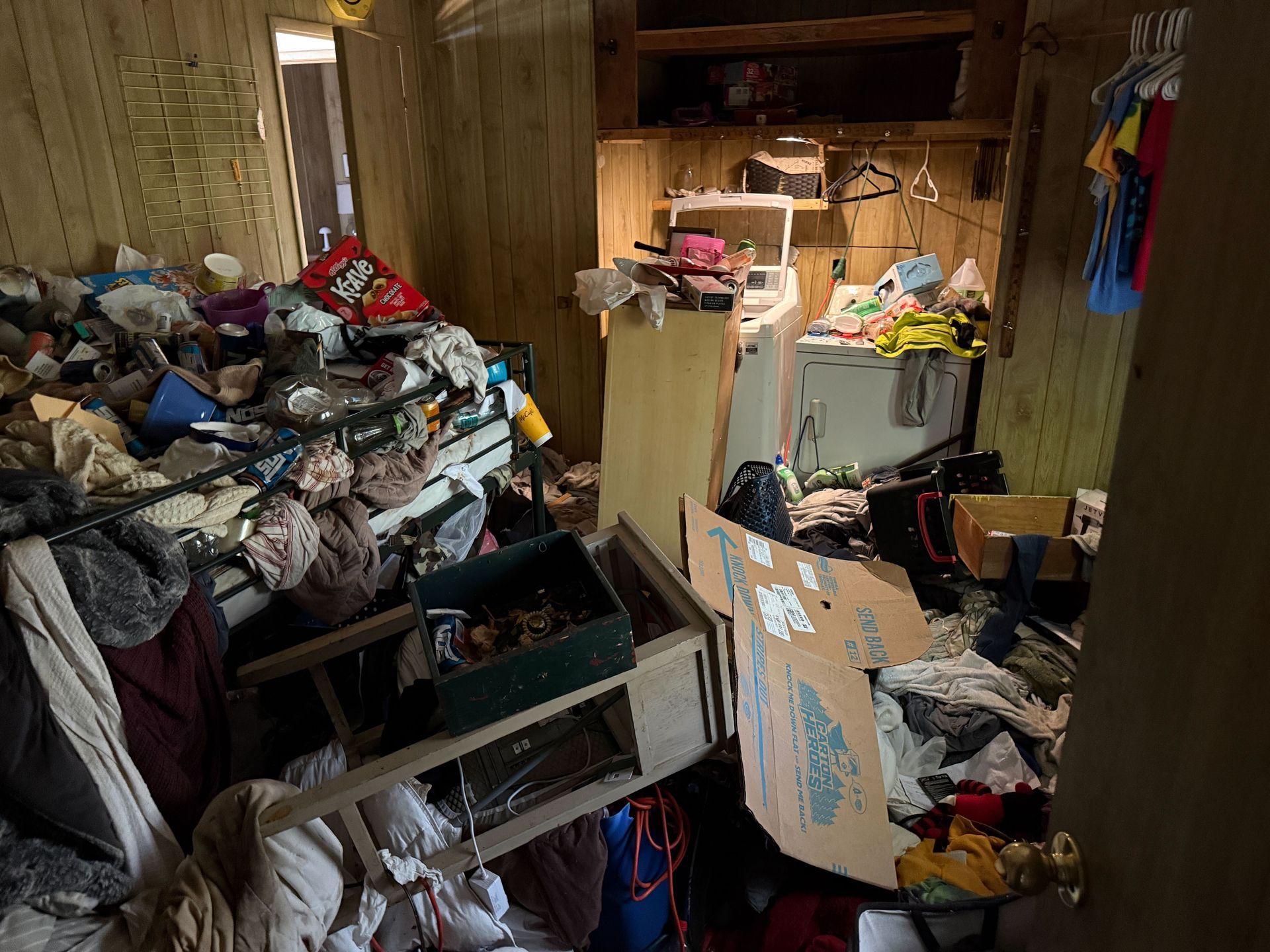 Hoarder cleanout in Gridley, CA — before: utility room crammed with junk, boxes and bags