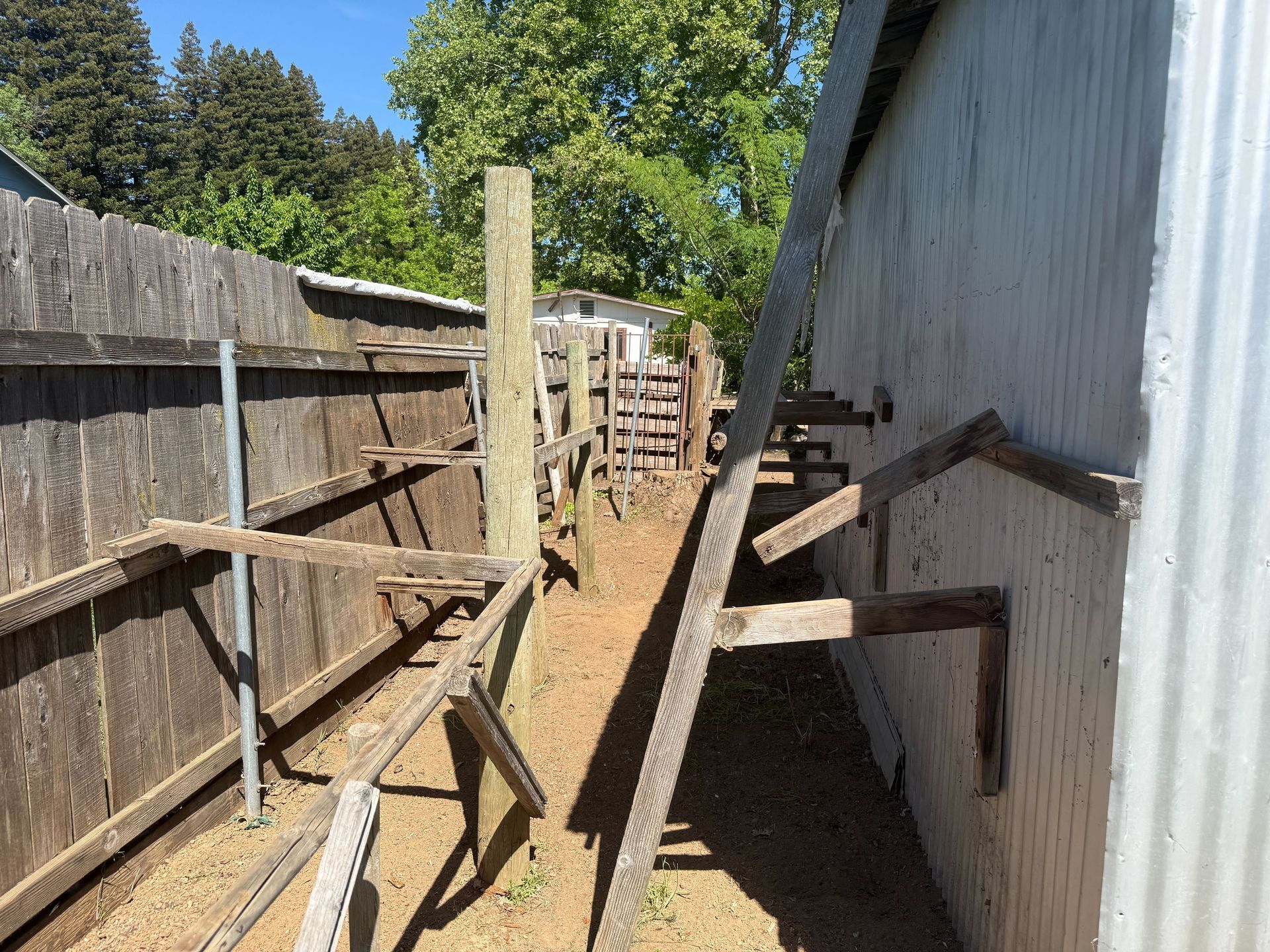Hoarder cleanout in Gridley, CA — wooden fence and gate structure on the property