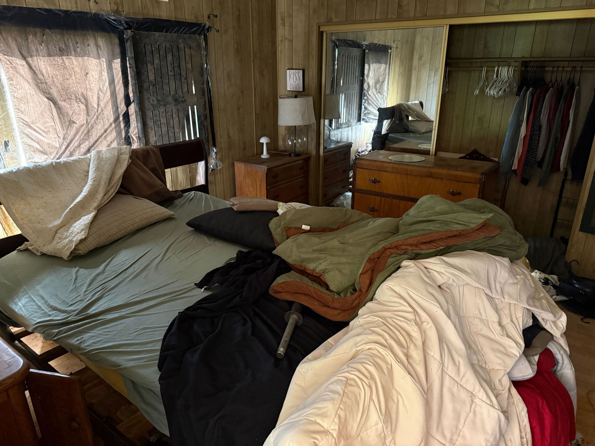 Hoarder cleanout in Gridley, CA — before: bedroom with unmade bed and clothes strewn about