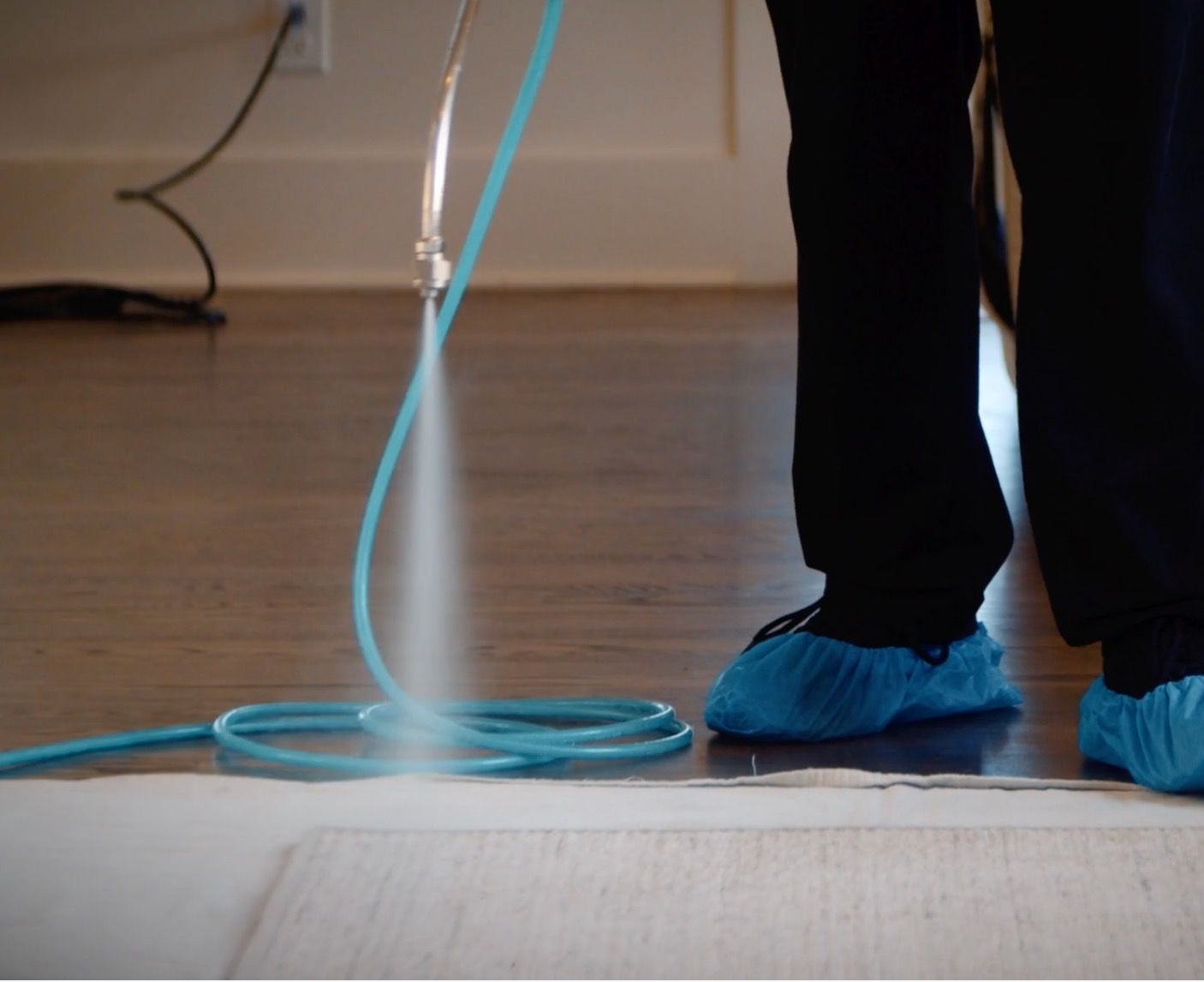 Handheld drill cleaning a beige carpet corner