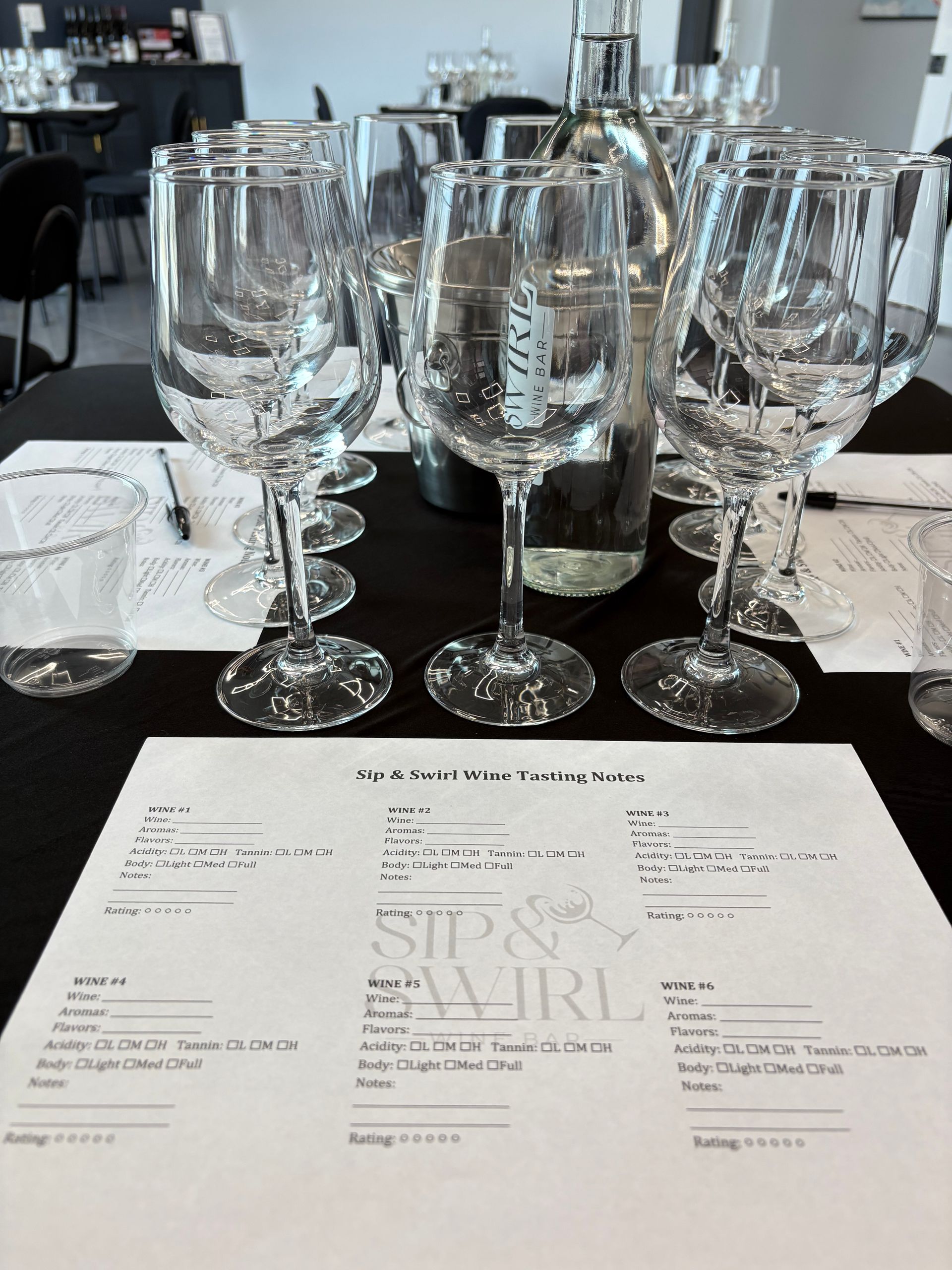 Two wine glasses clink over a charcuterie board and appetizers at a restaurant table.