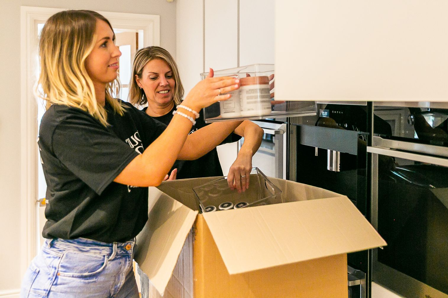 unpacking team London and Home Counties Female unpacking team organising a new kitchen after the removal company has delivered moving boxes. (100
characters)
