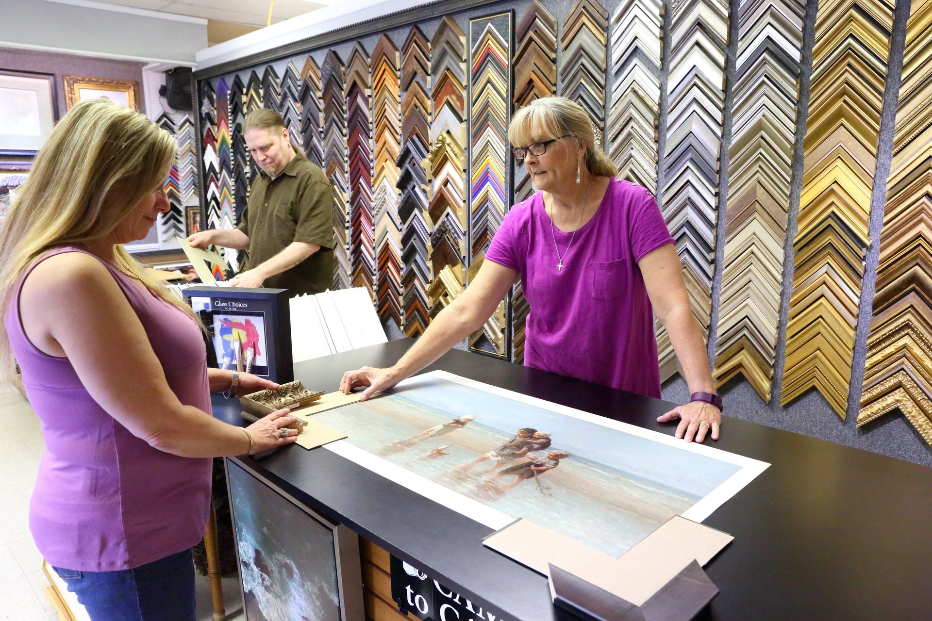 Employee Assisting Client at Local Custom Framing Business