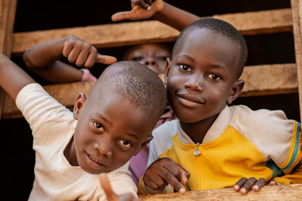 Three young boys are standing next to each other and smiling for the camera.