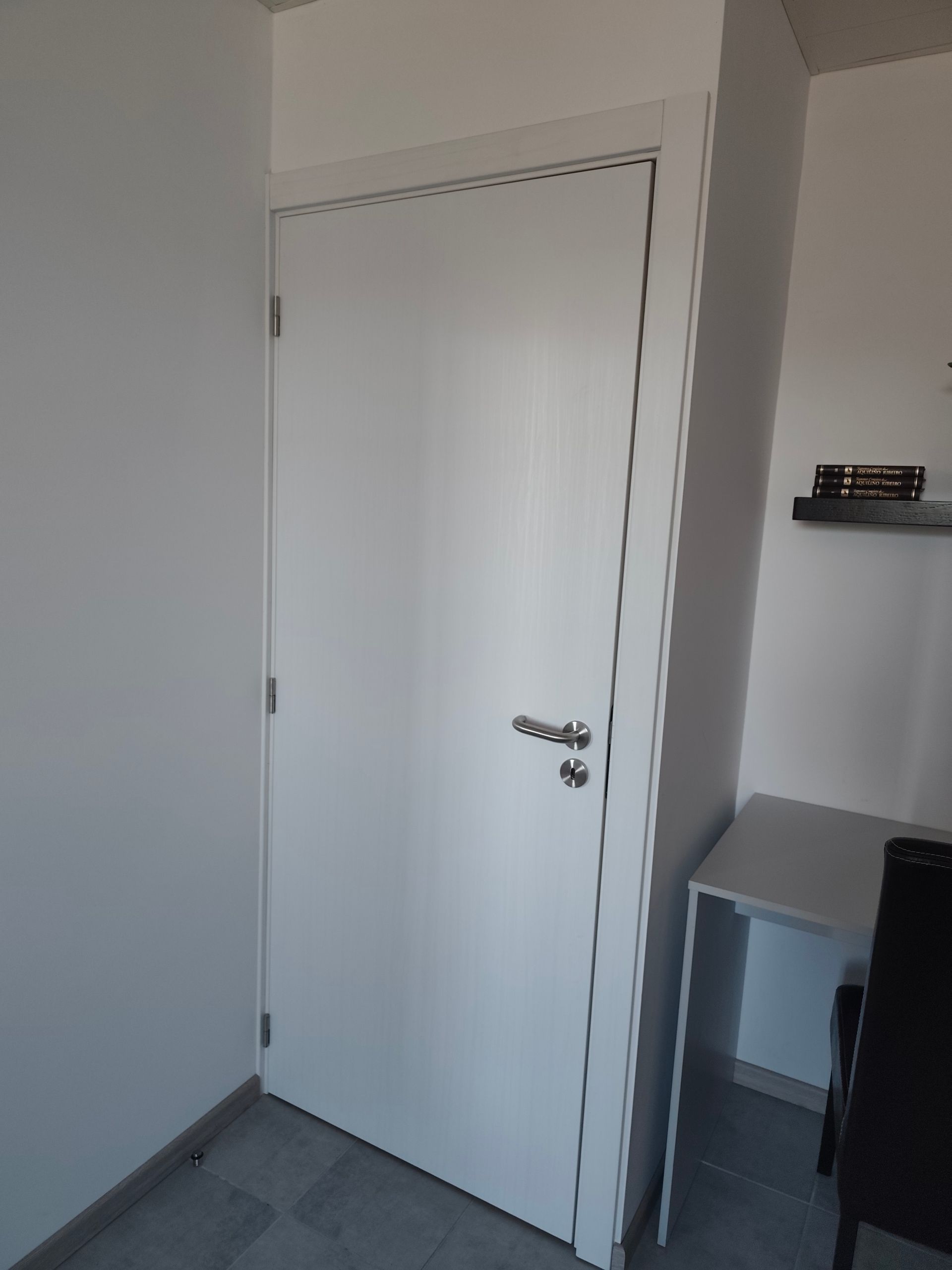 Porta interior branca aplicada pela Jorge Móveis com todos os ajustes necessários em obra