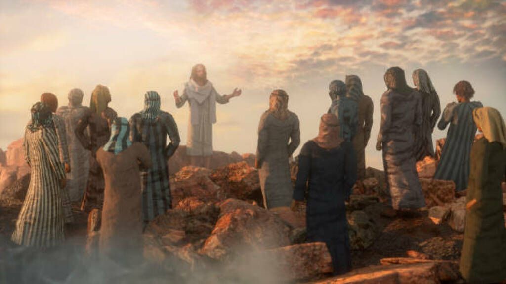 A robed figure addresses a small group on a rocky hill at sunset, with warm light and mist in the background.