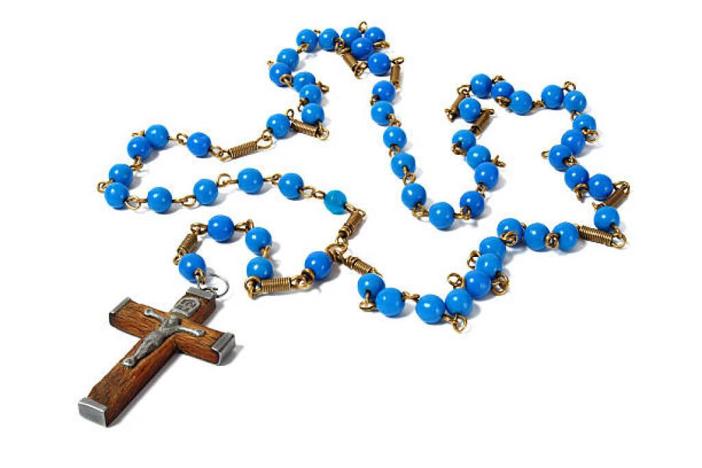 Rosary beads with blue accents and a wooden crucifix on a white background