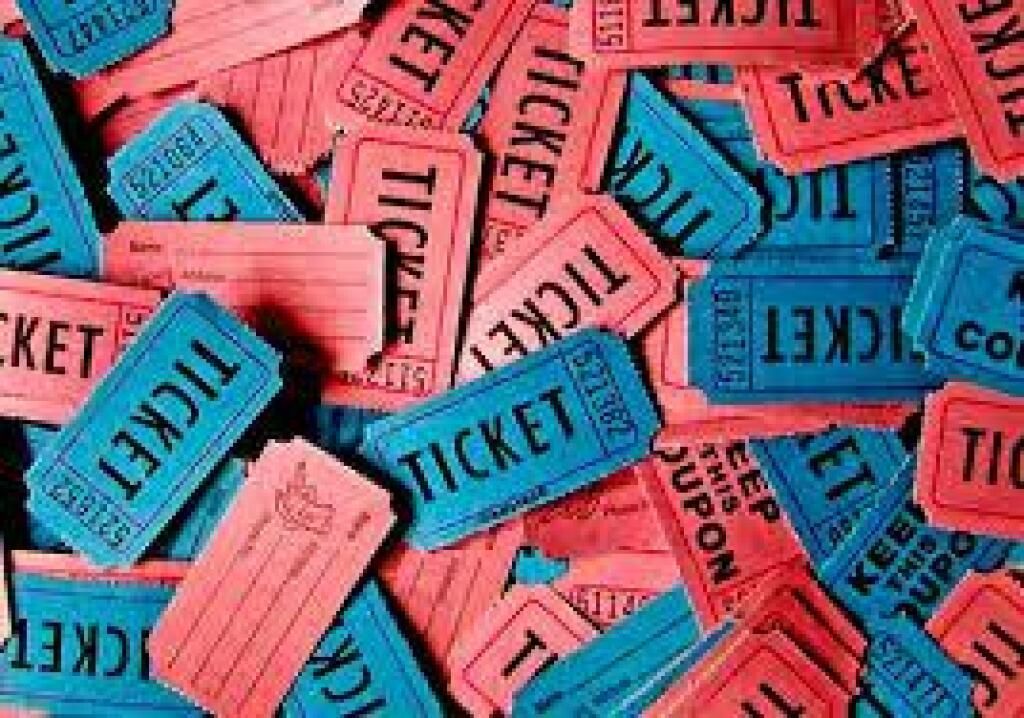 Pile of colorful ticket stubs in pink, blue, and coral, scattered in a close-up view
