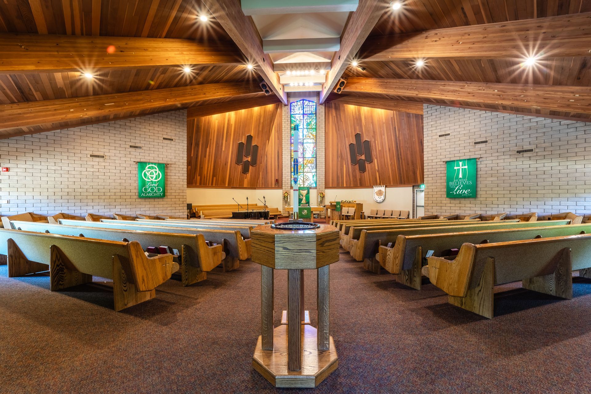 A church with wooden benches and a stained glass window.