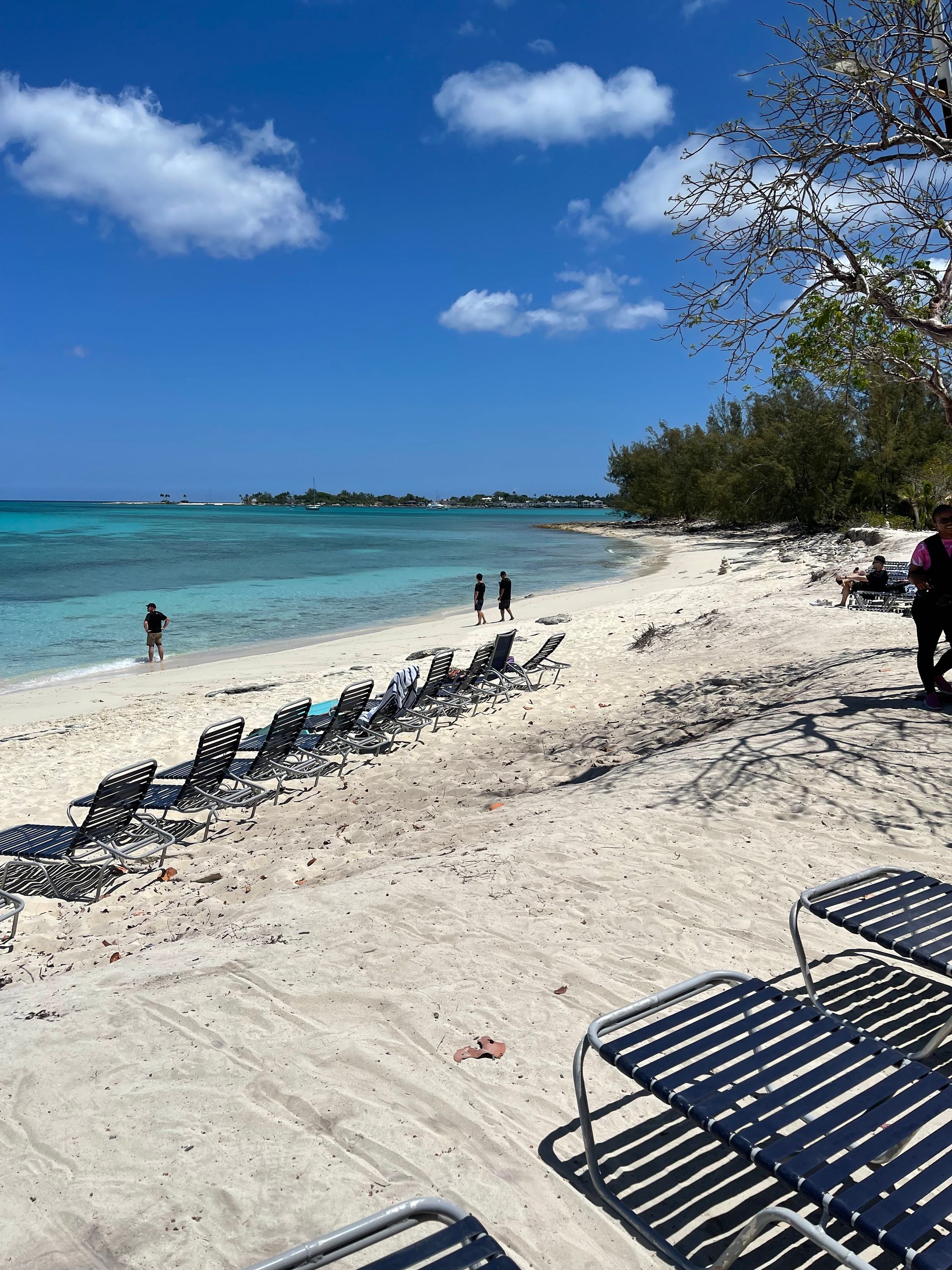 Beach scene with turquoise water, white sand, and blue sky.