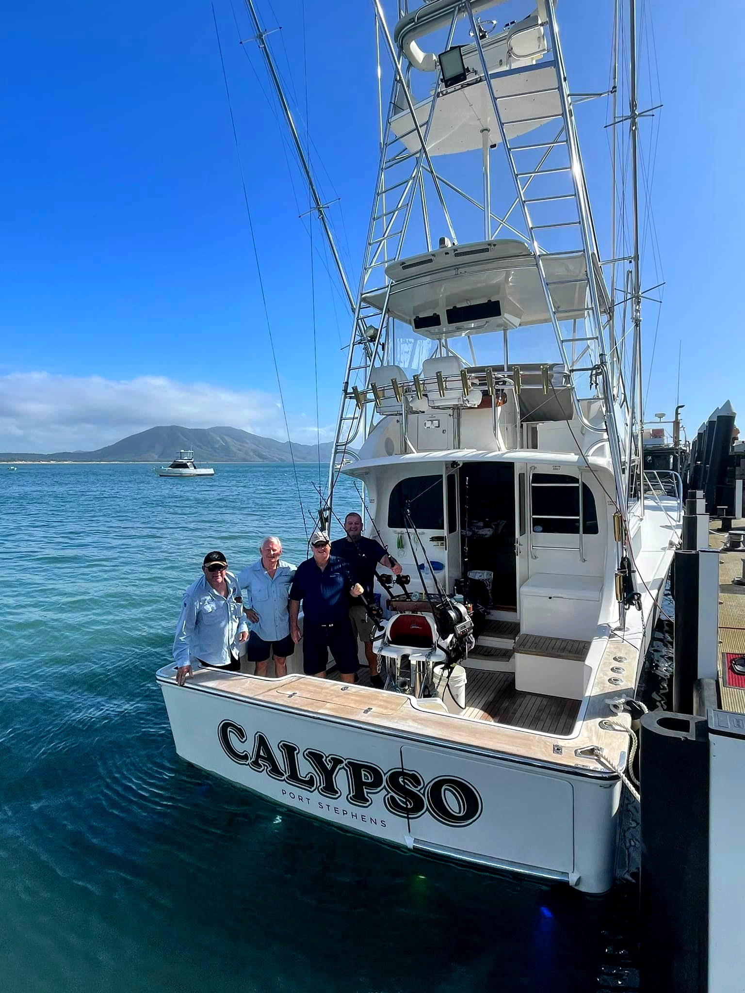 People standing on the back of a boat named