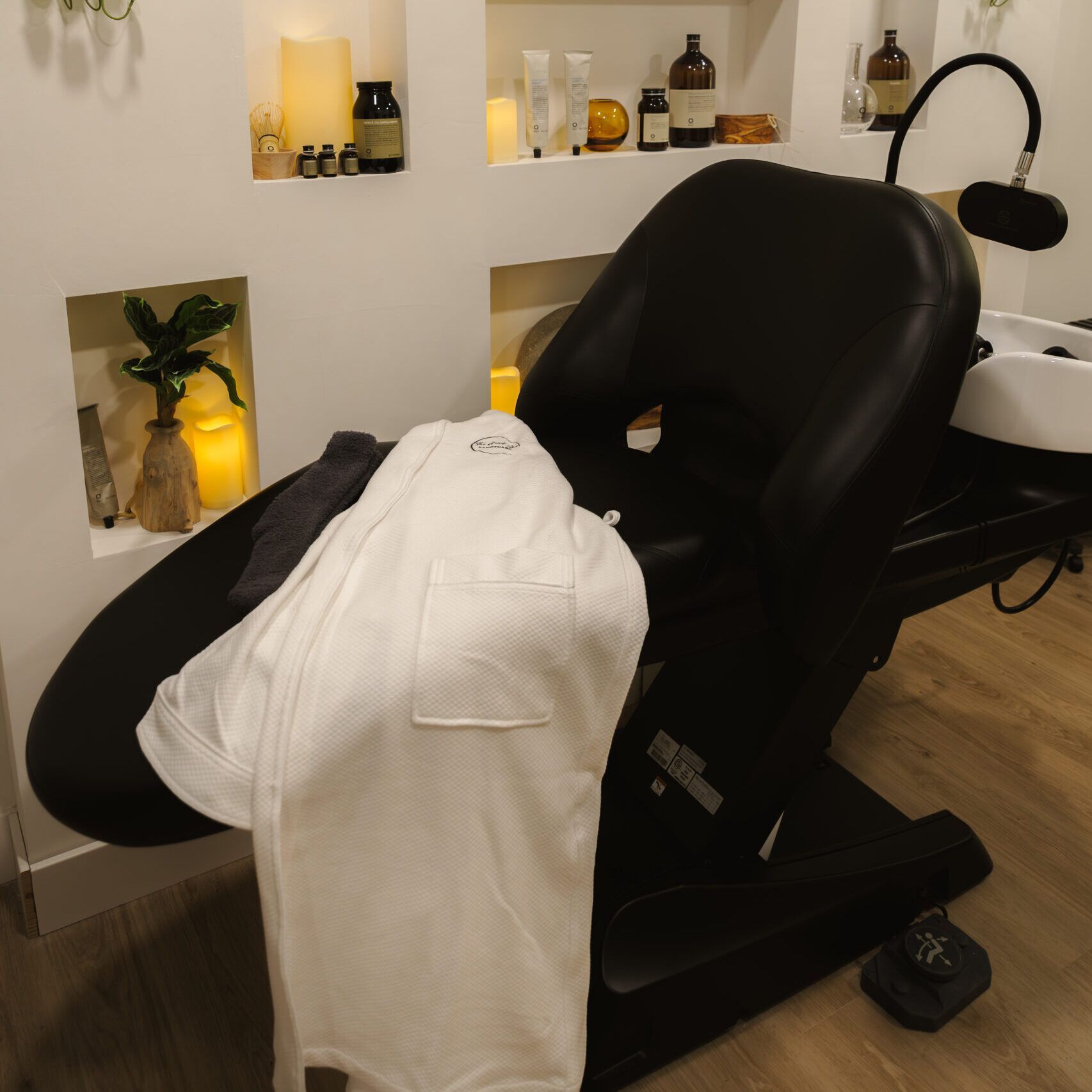 A white shirt is laying on a black chair in a salon