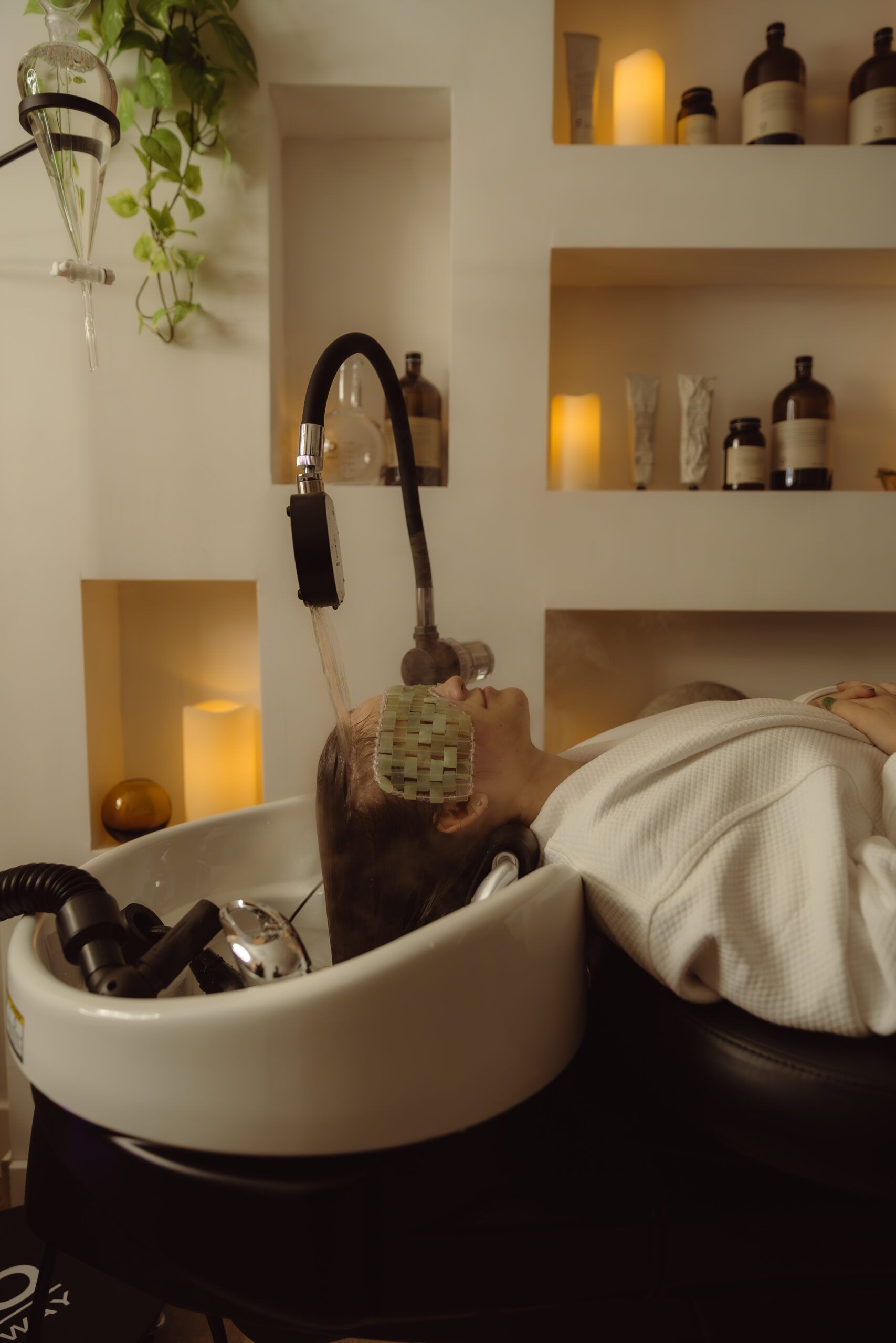 A man is getting his hair washed in a sink at a salon.