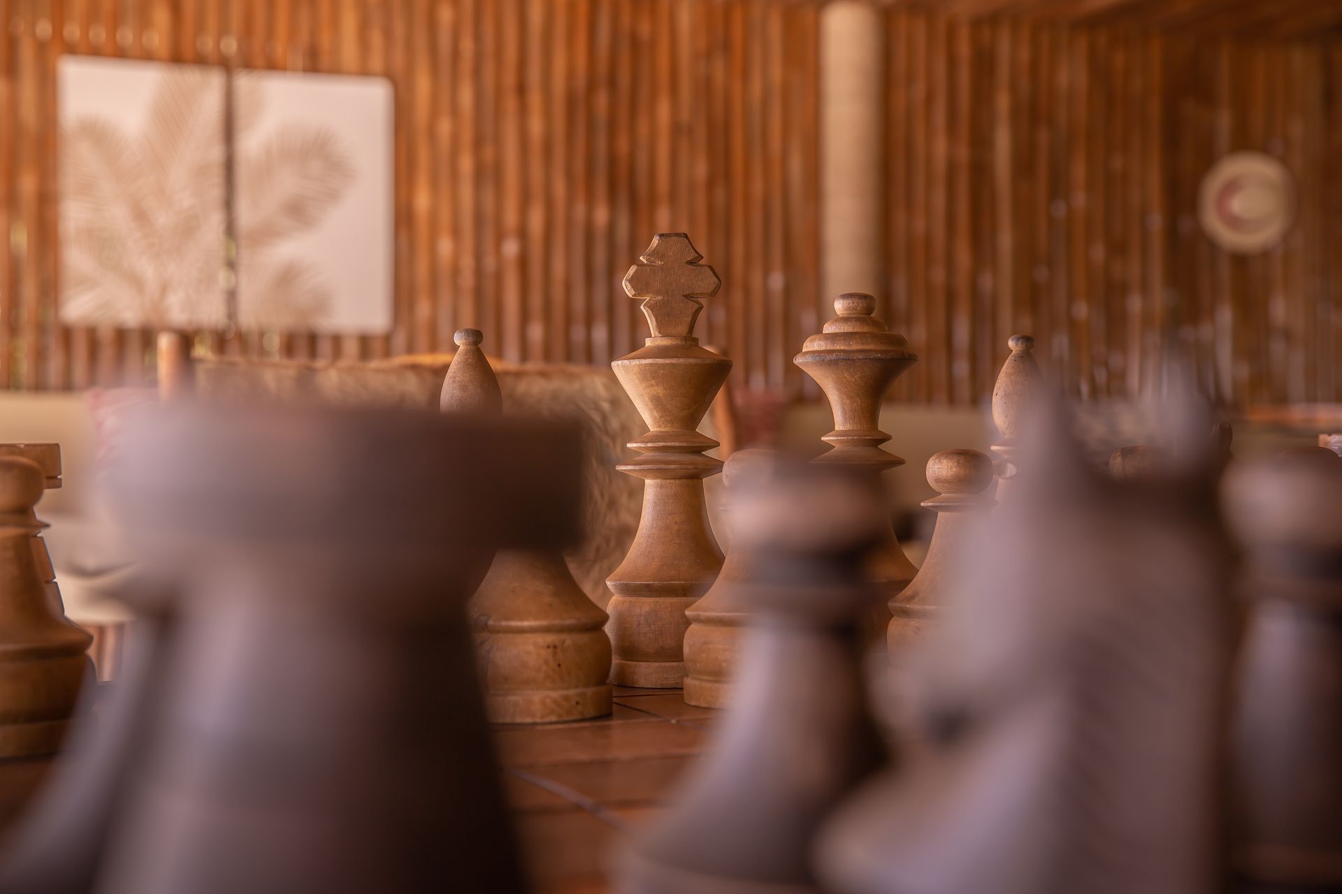 A bunch of wooden chess pieces are sitting on a wooden table.