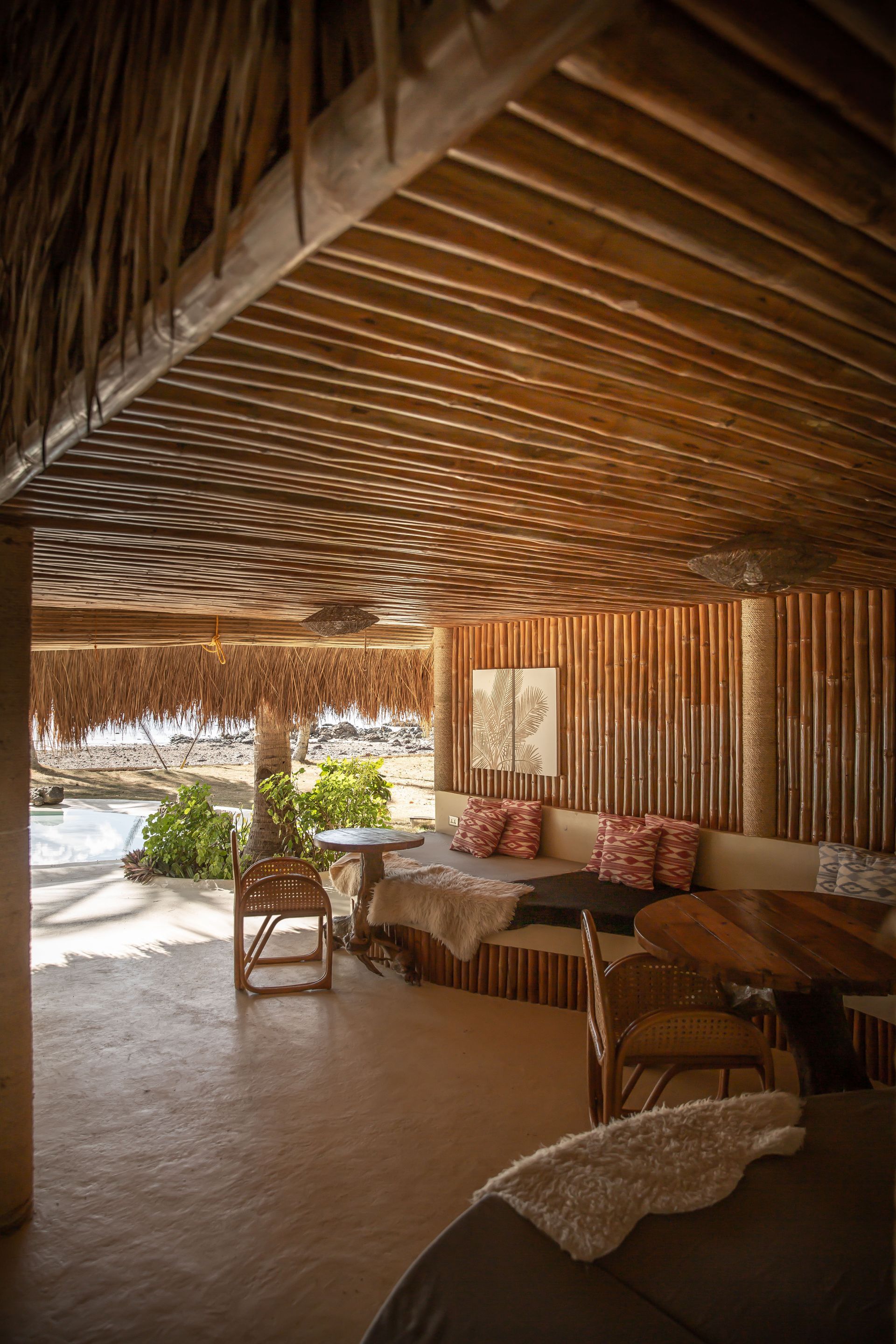 A living room with a thatched roof and wooden furniture.