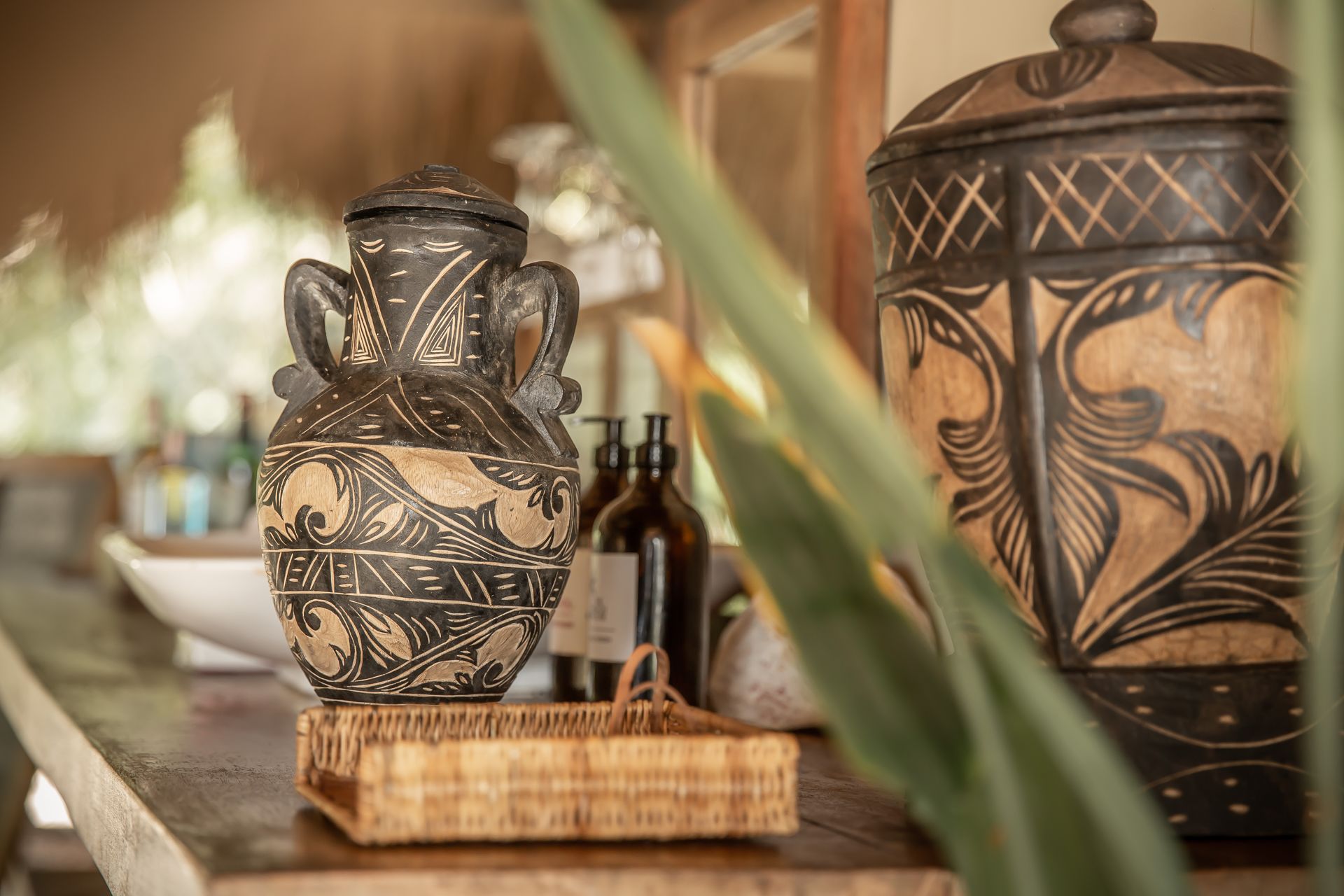 A couple of vases sitting on top of a wooden table.