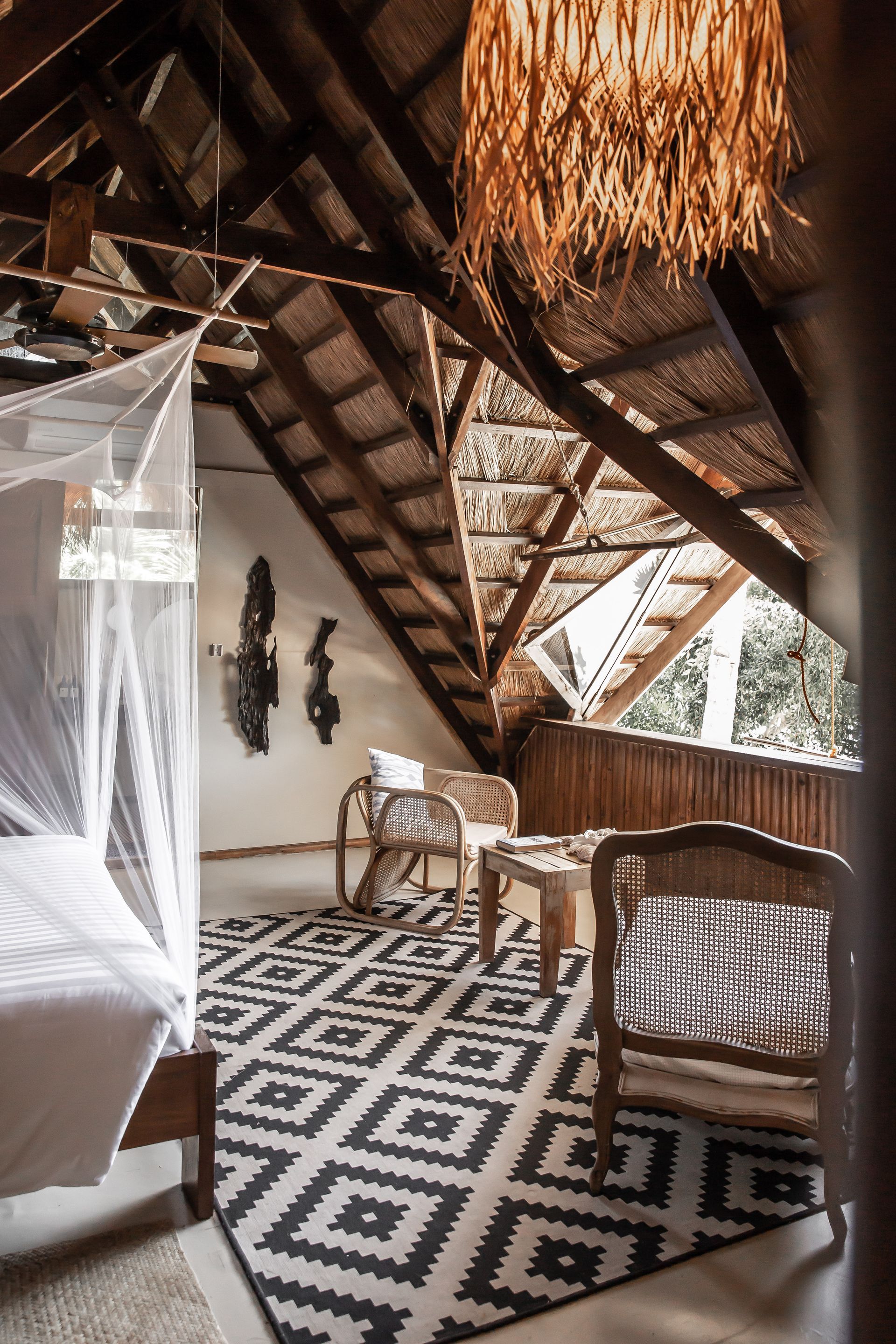 A bedroom with a canopy bed , chairs , and a rug.