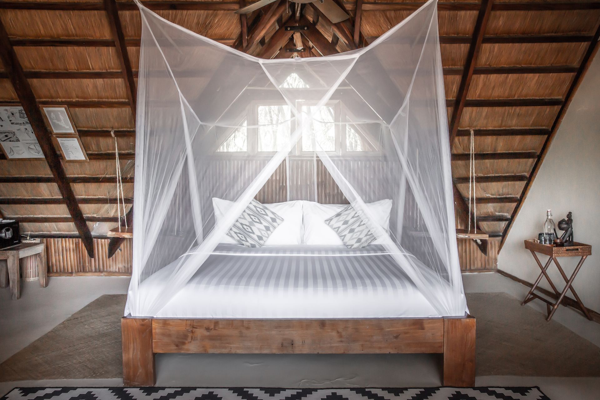 A bedroom with a canopy bed and a mosquito net