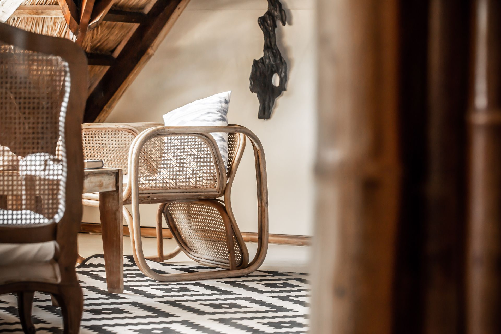 A living room with wicker furniture and a rug.