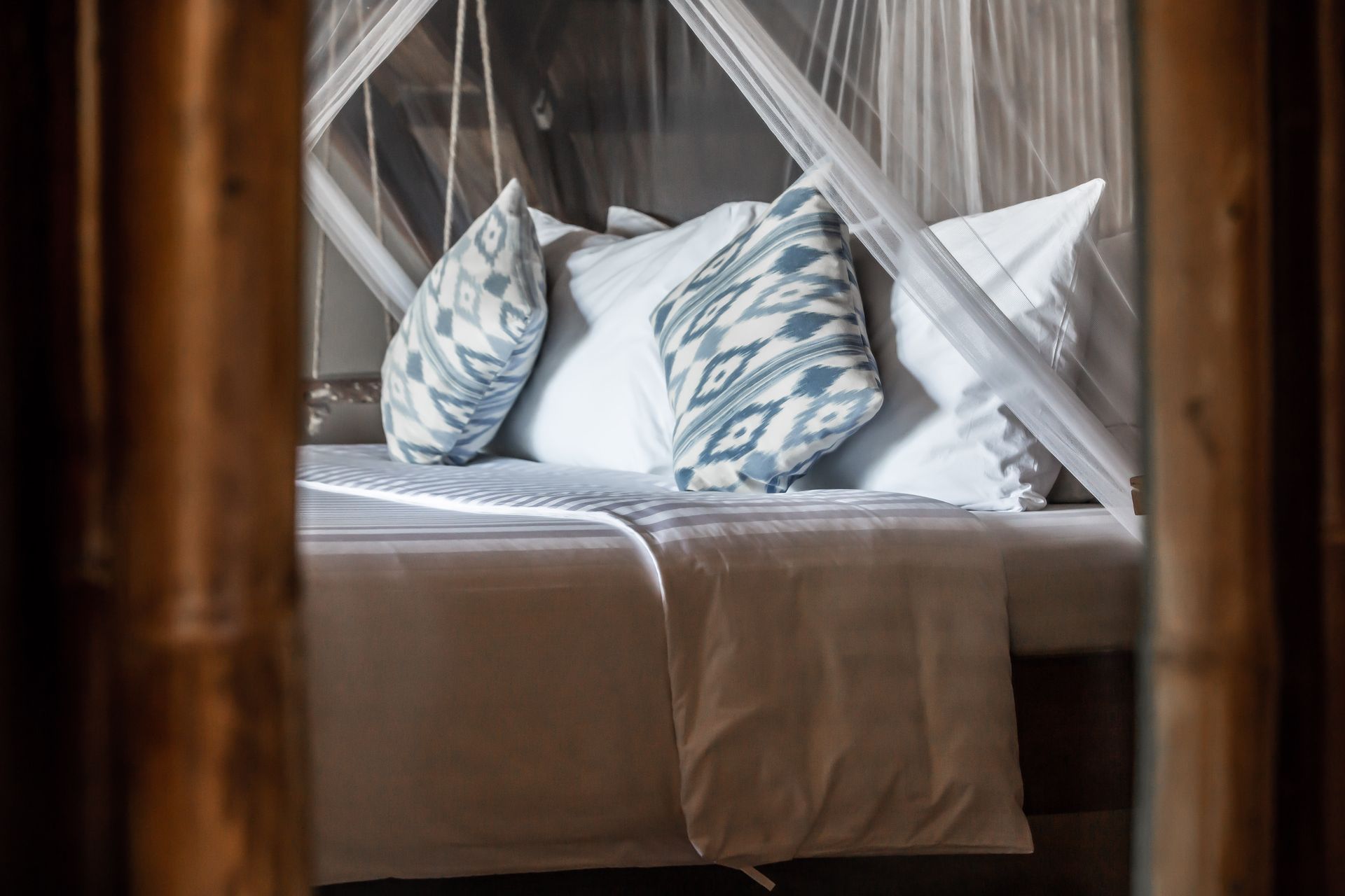 A bed with a canopy and pillows in a hotel room.
