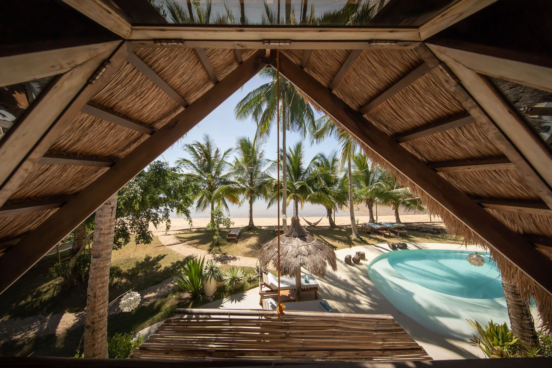 A view of a swimming pool from inside a hut