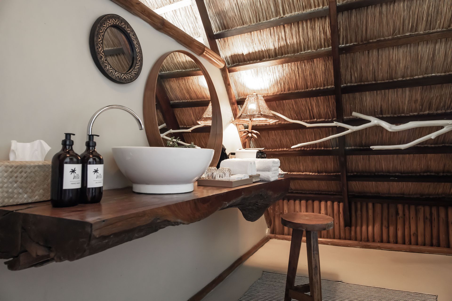 A bathroom with a sink , mirror and soap bottles