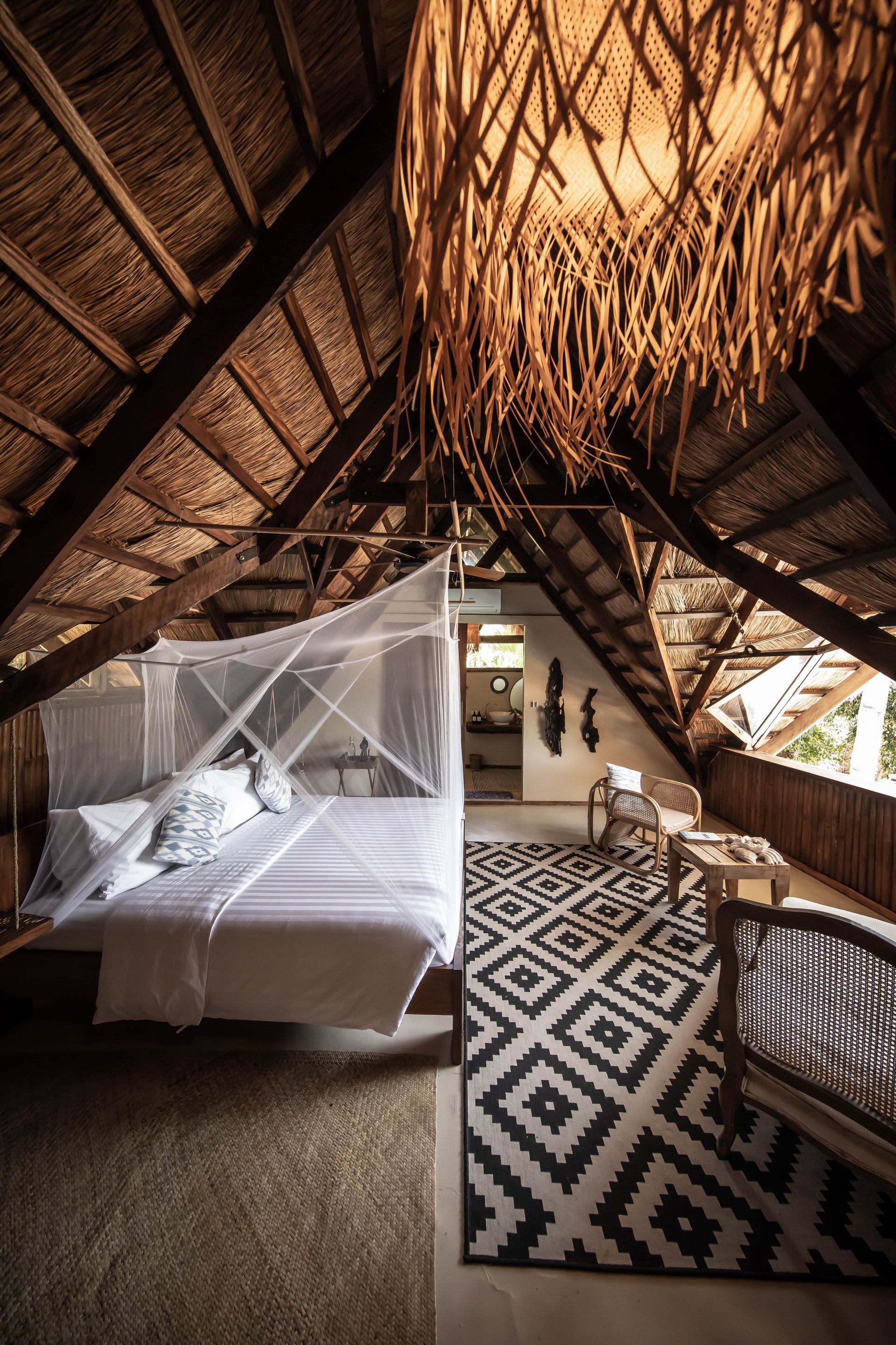 There is a bed in the attic with a mosquito net.