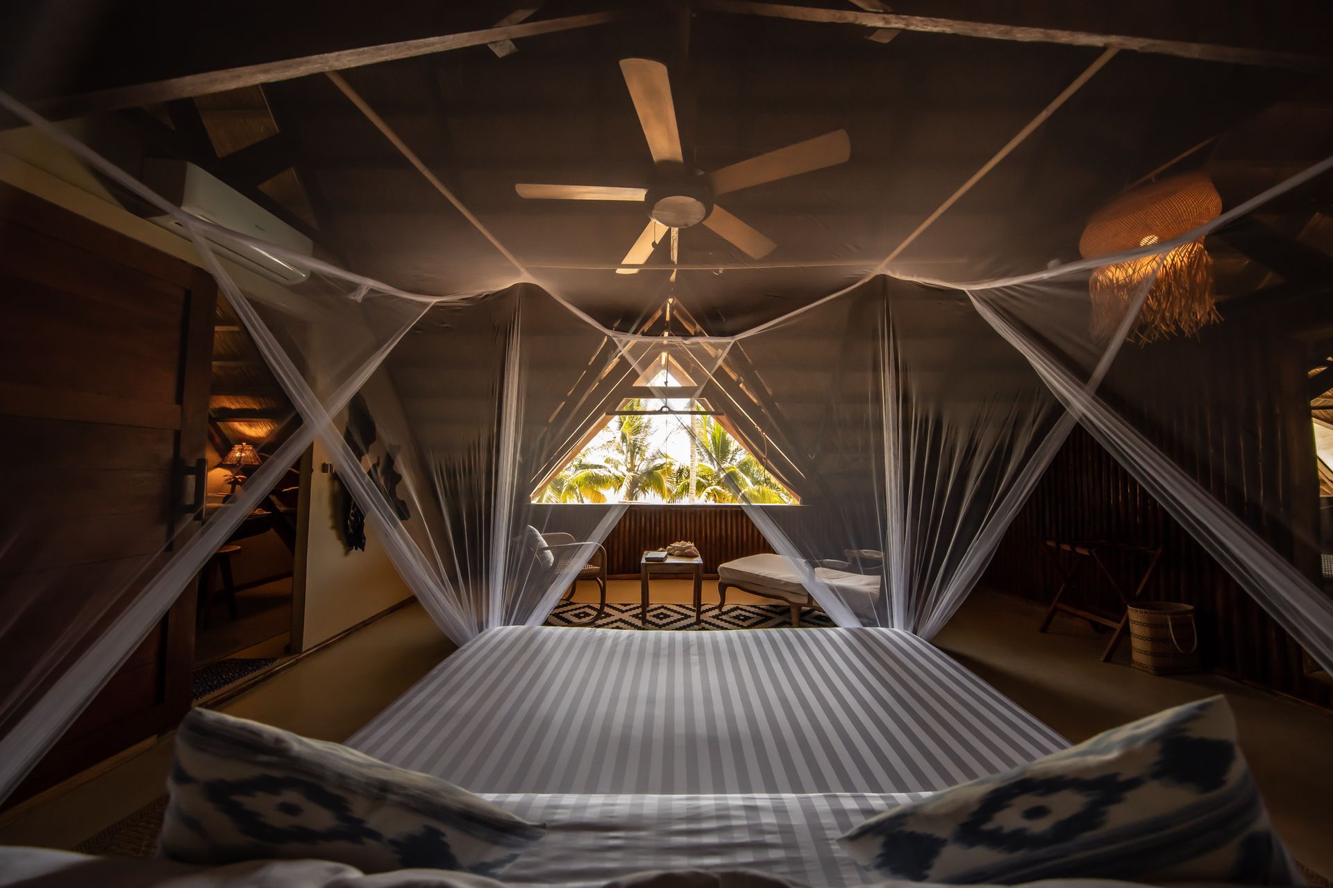 A bedroom with a canopy bed and a ceiling fan