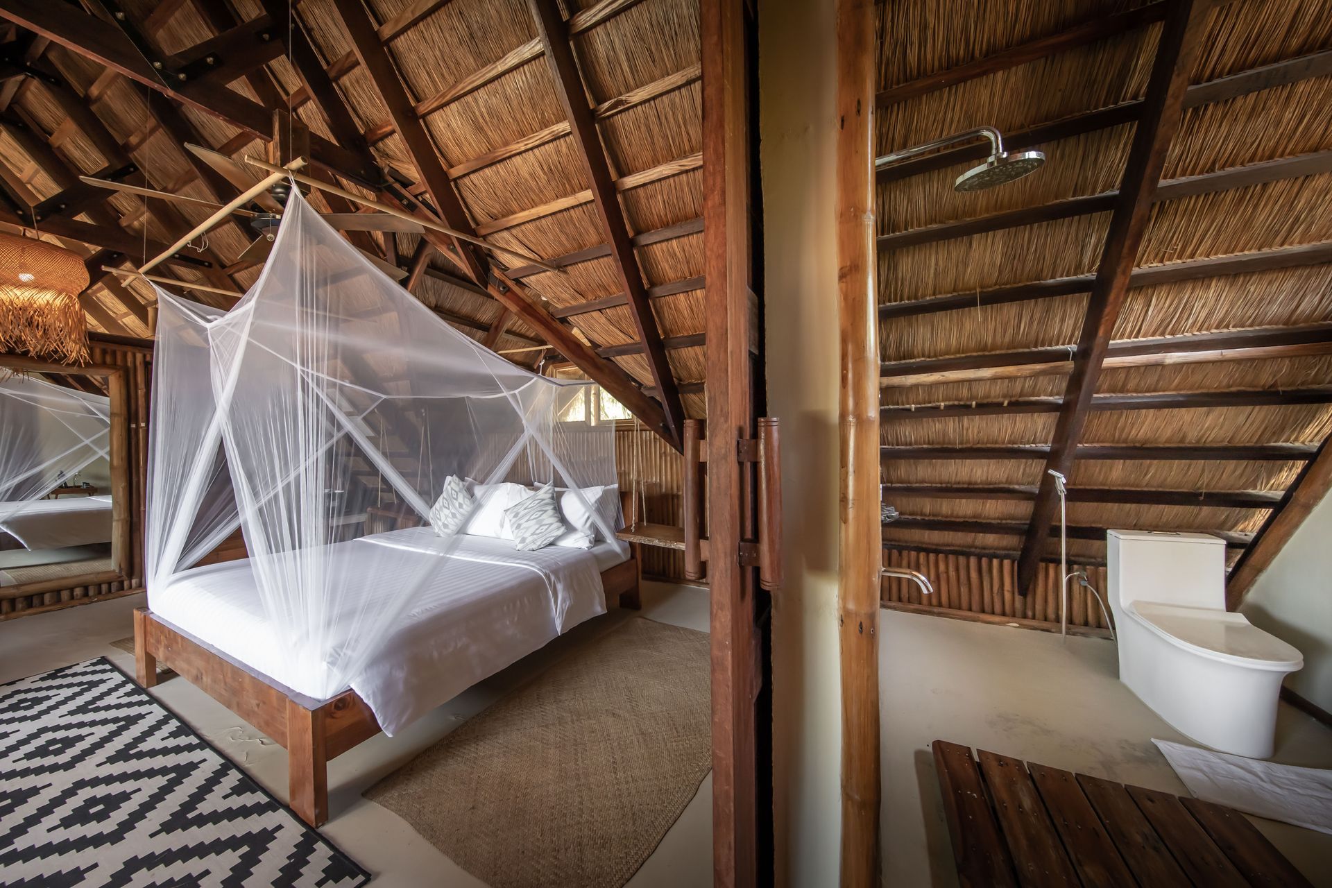 A bedroom with a canopy bed and a bathtub.