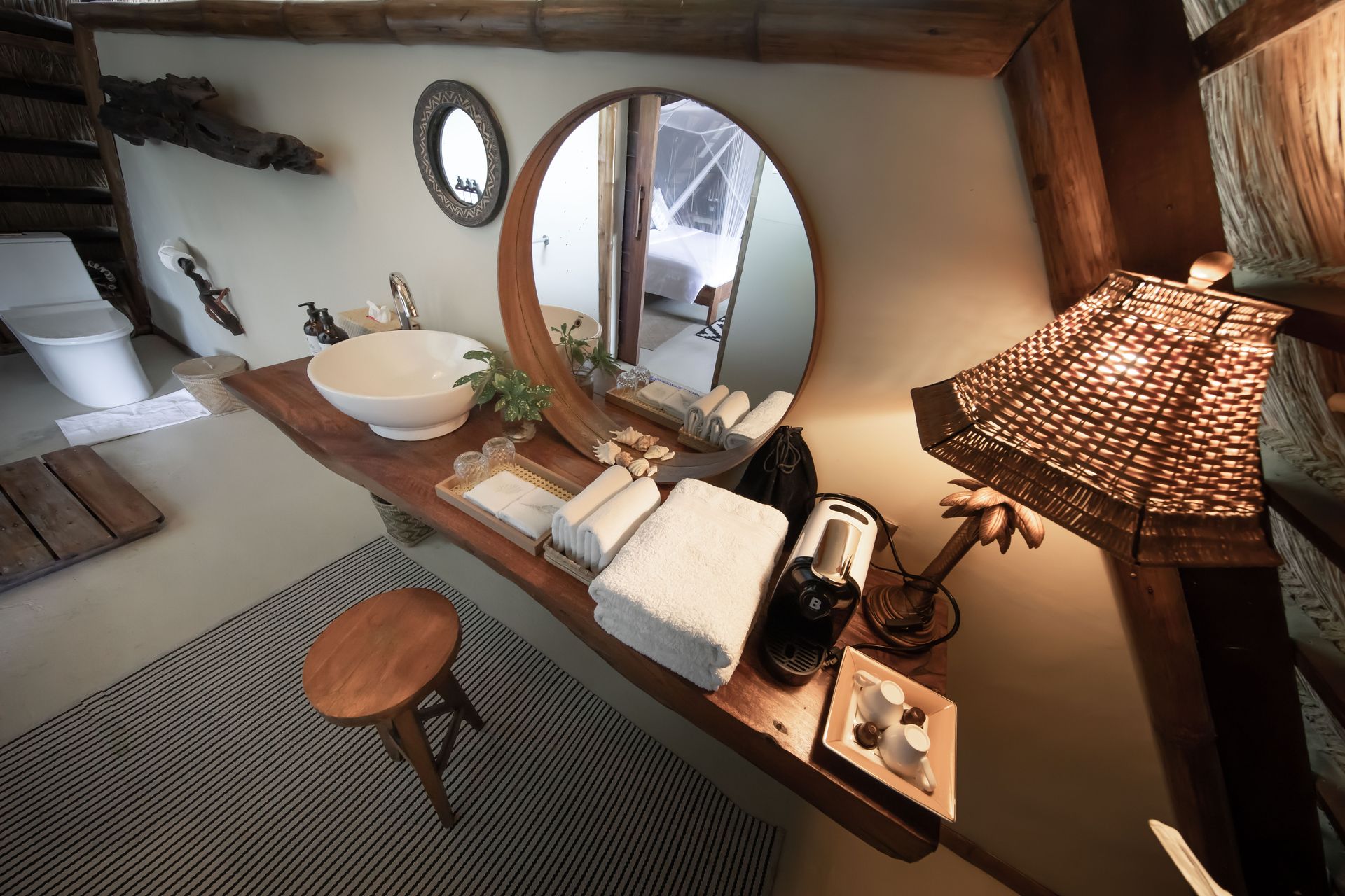 A bathroom with a sink and a round mirror