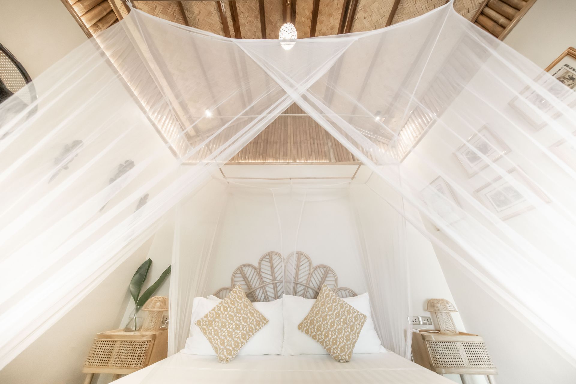 A bedroom with a canopy bed and a mosquito net.