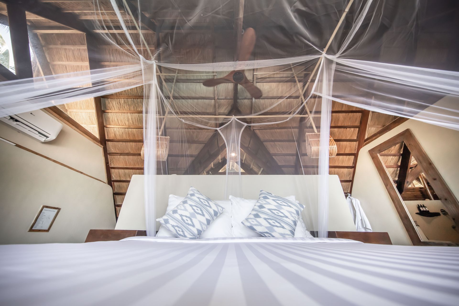 A bedroom with a canopy bed and a ceiling fan.
