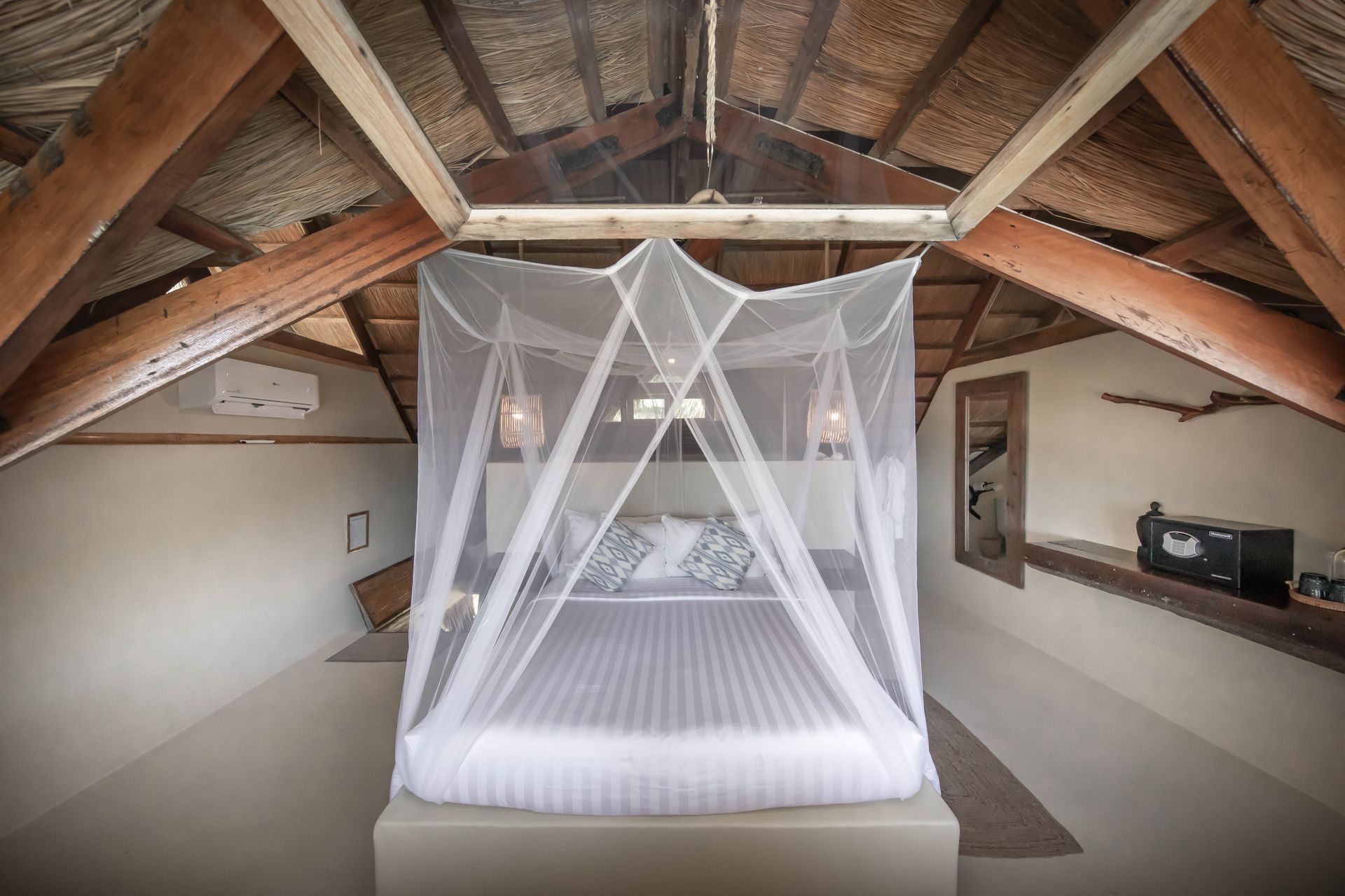 A bed with a mosquito net hanging from the ceiling