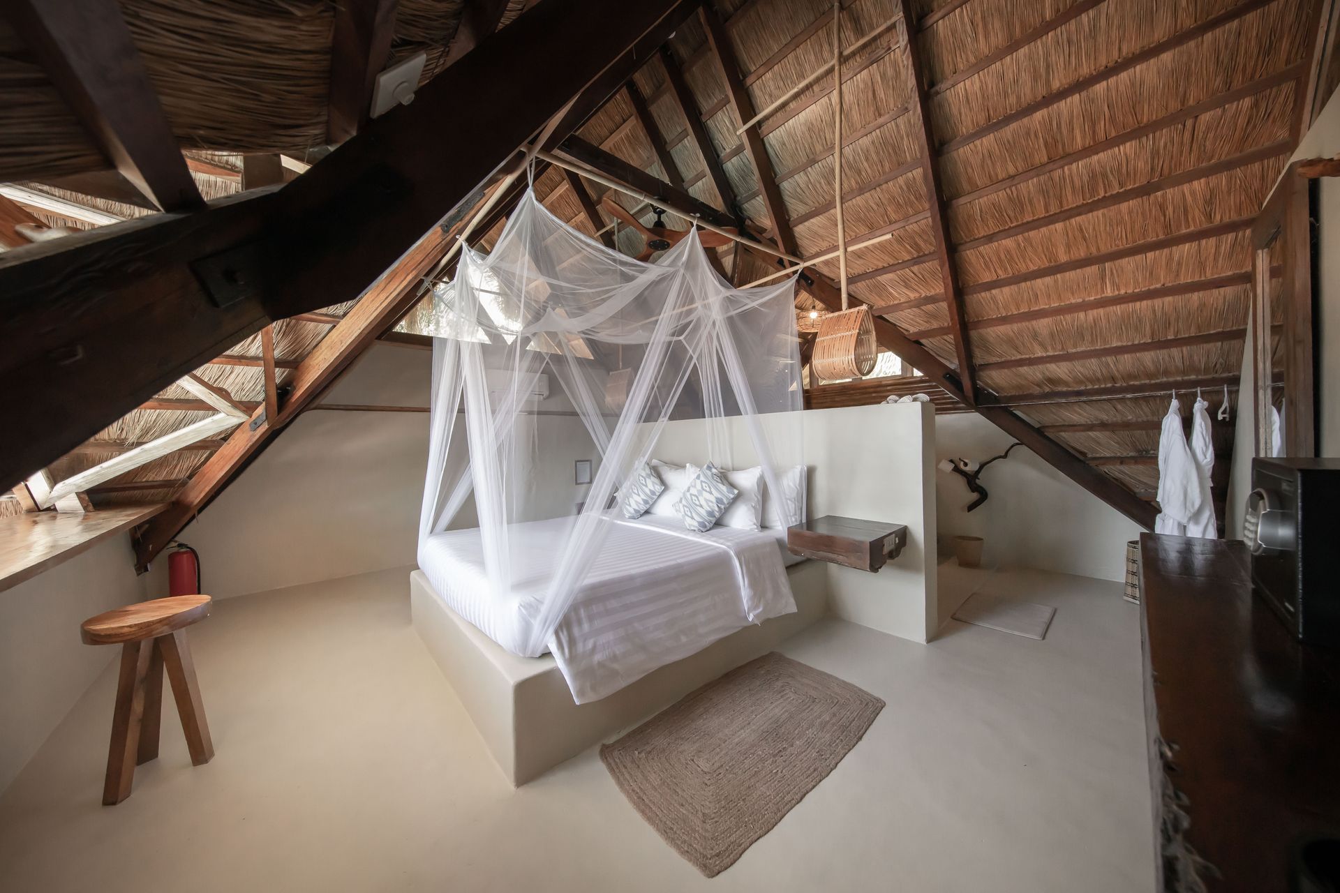 A bedroom with a canopy bed in the attic.