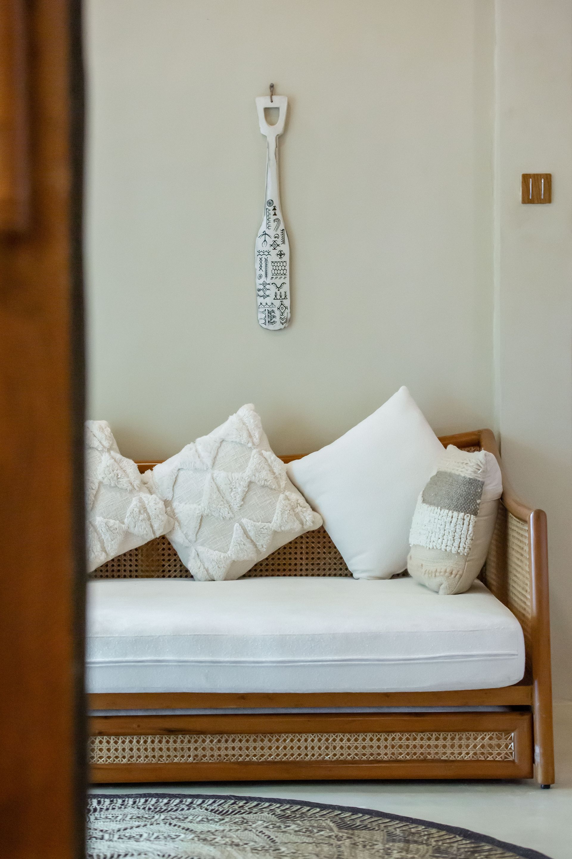 There is a couch with white pillows on it in the corner of the room.
