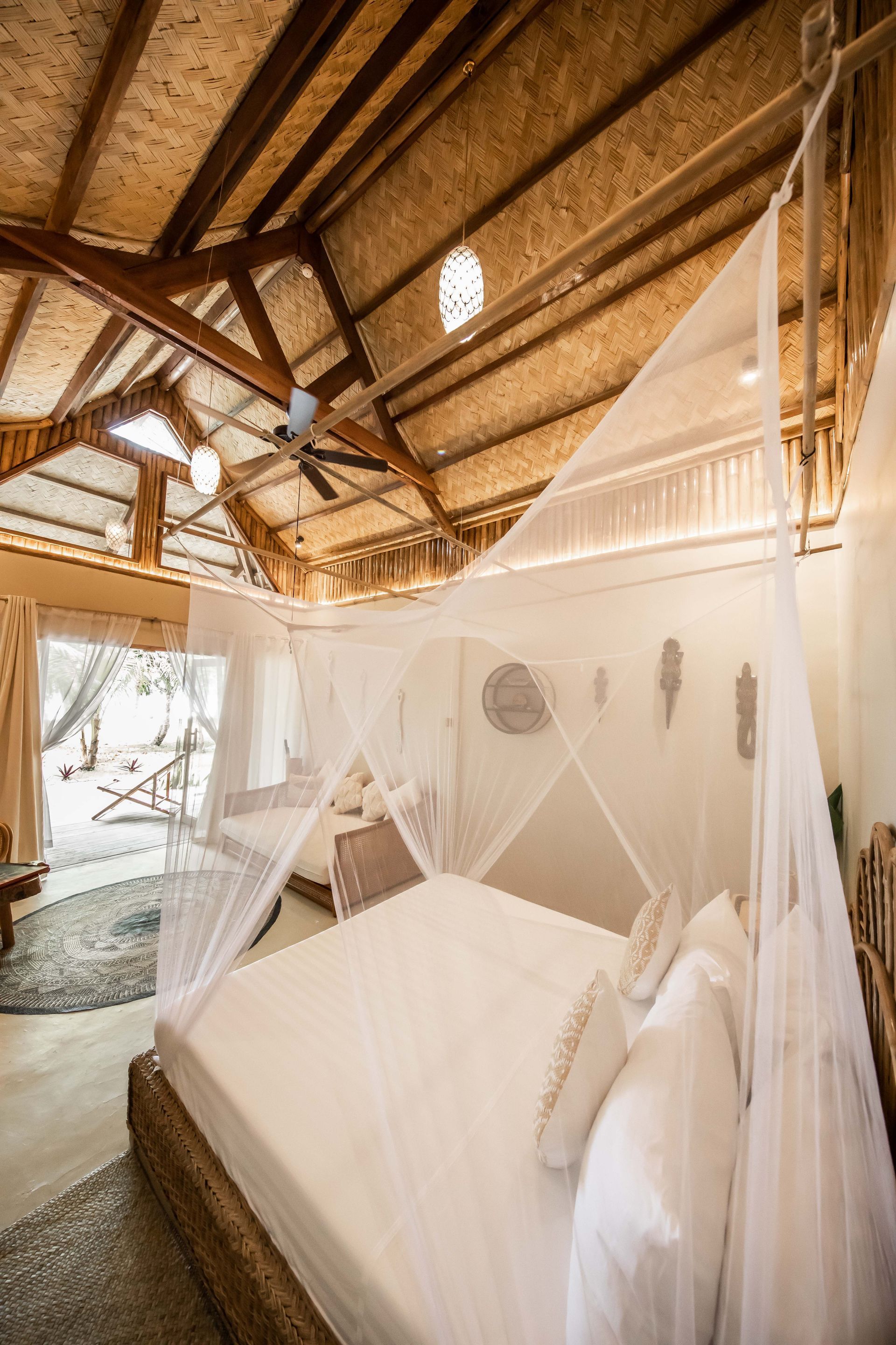 A bedroom with a canopy bed and a ceiling fan.