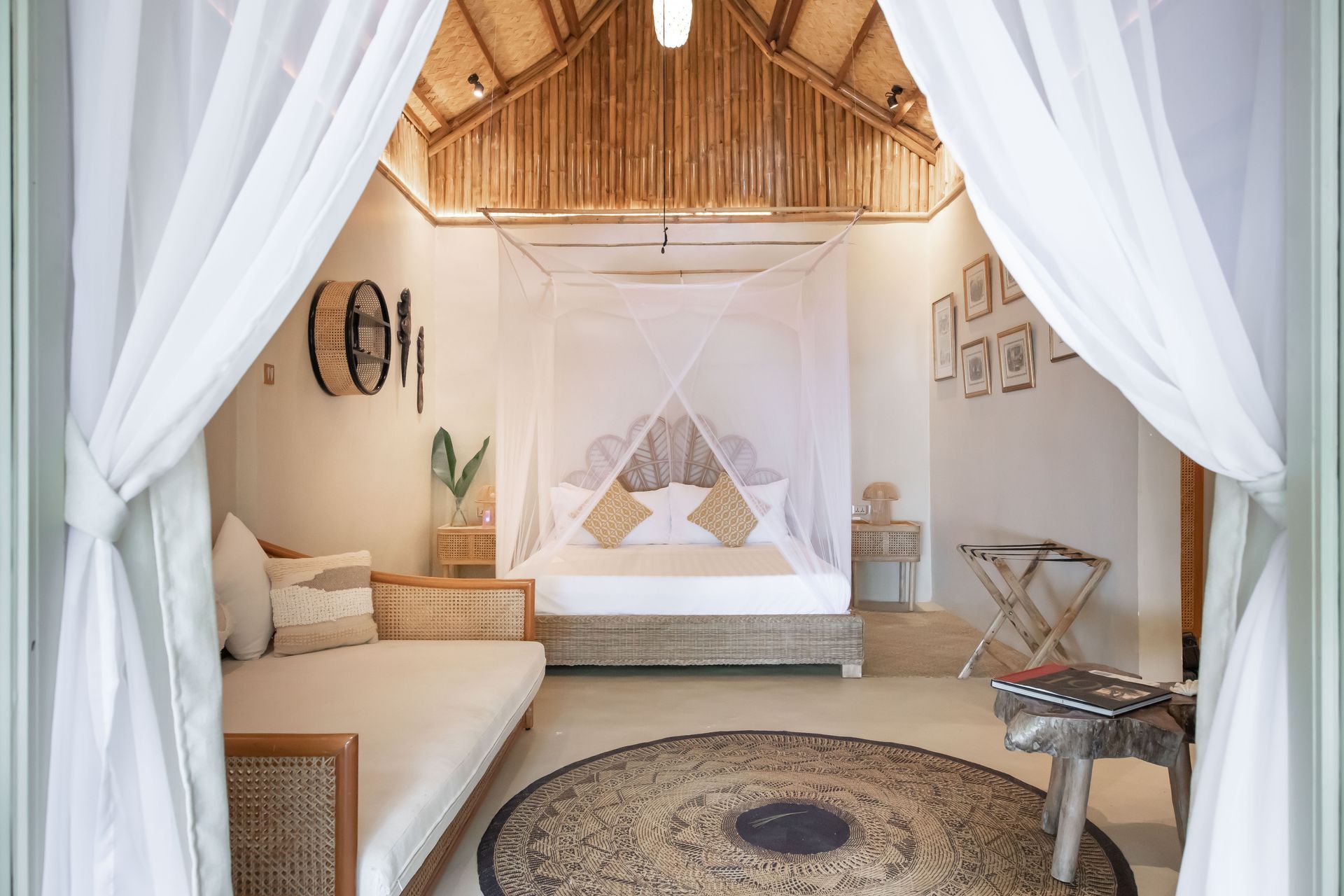 A bedroom with a canopy bed , a couch , and a rug.