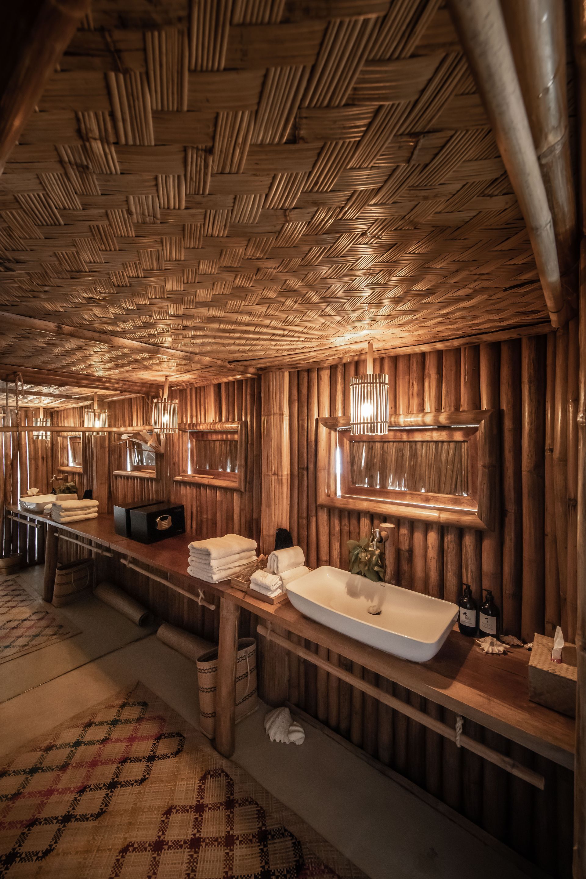 A bathroom with a wooden ceiling , sinks and mirrors.