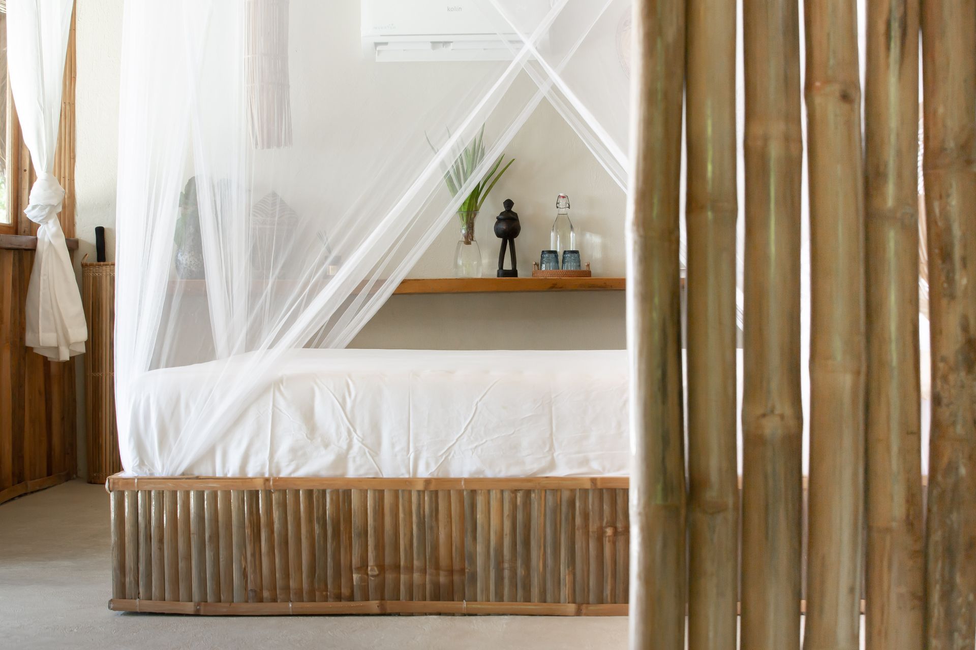 A bedroom with a canopy bed and a wooden fence.