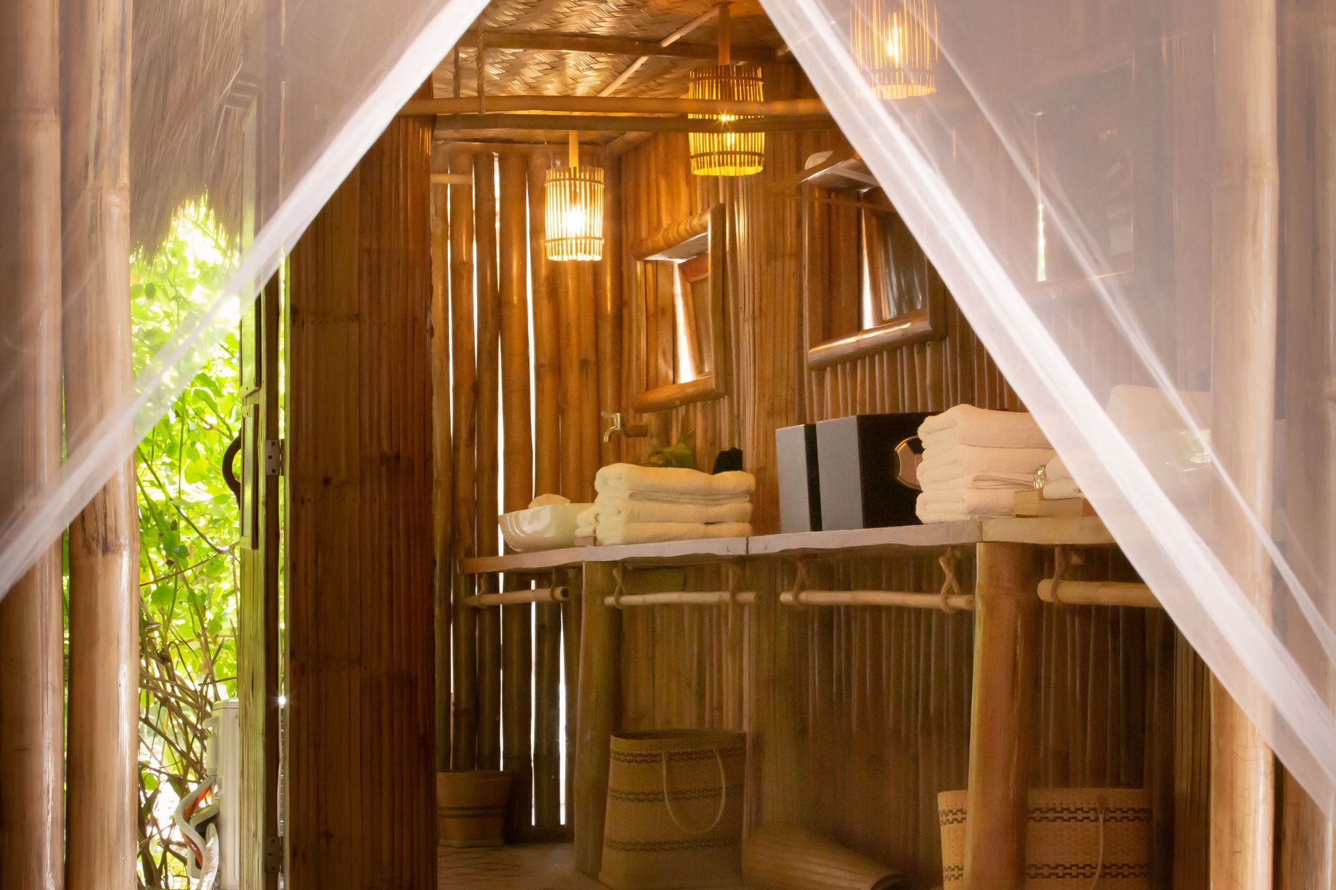 A room with a mosquito net and a table with towels on it